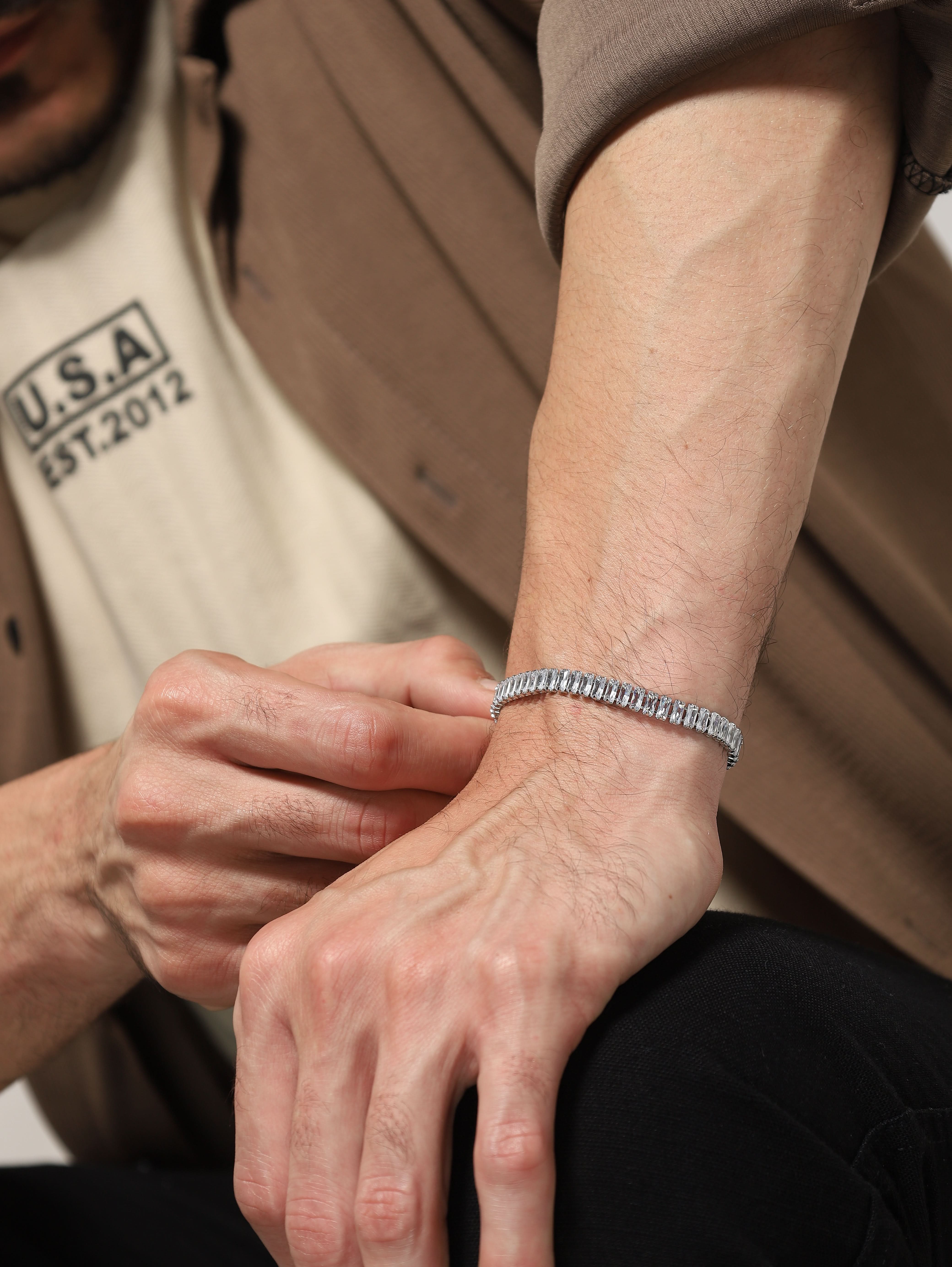 Side view of silver baguette tennis bracelet styled on a man's wrist