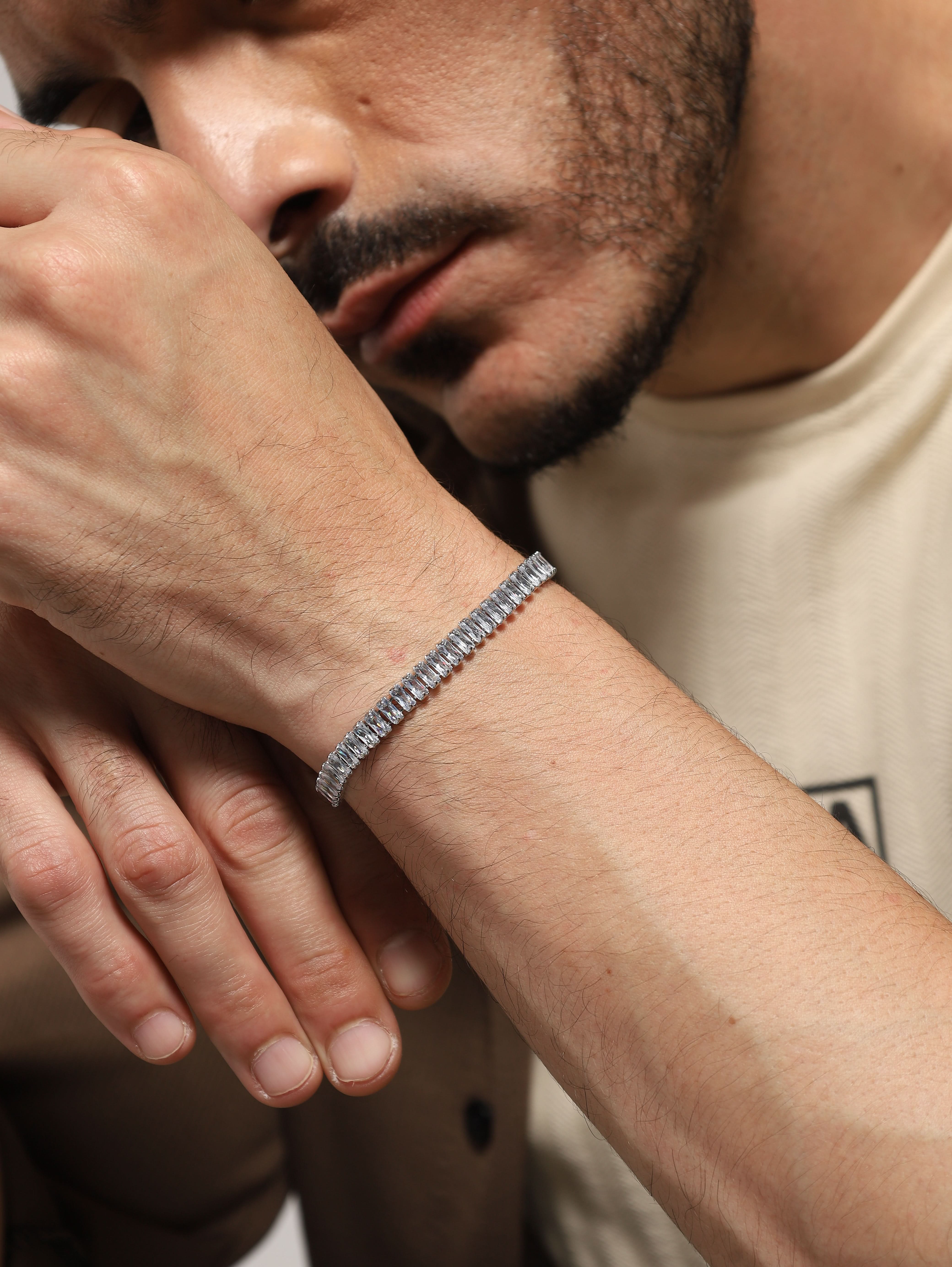 Detail shot of silver tennis bracelet baguette stones on a man's wrist
