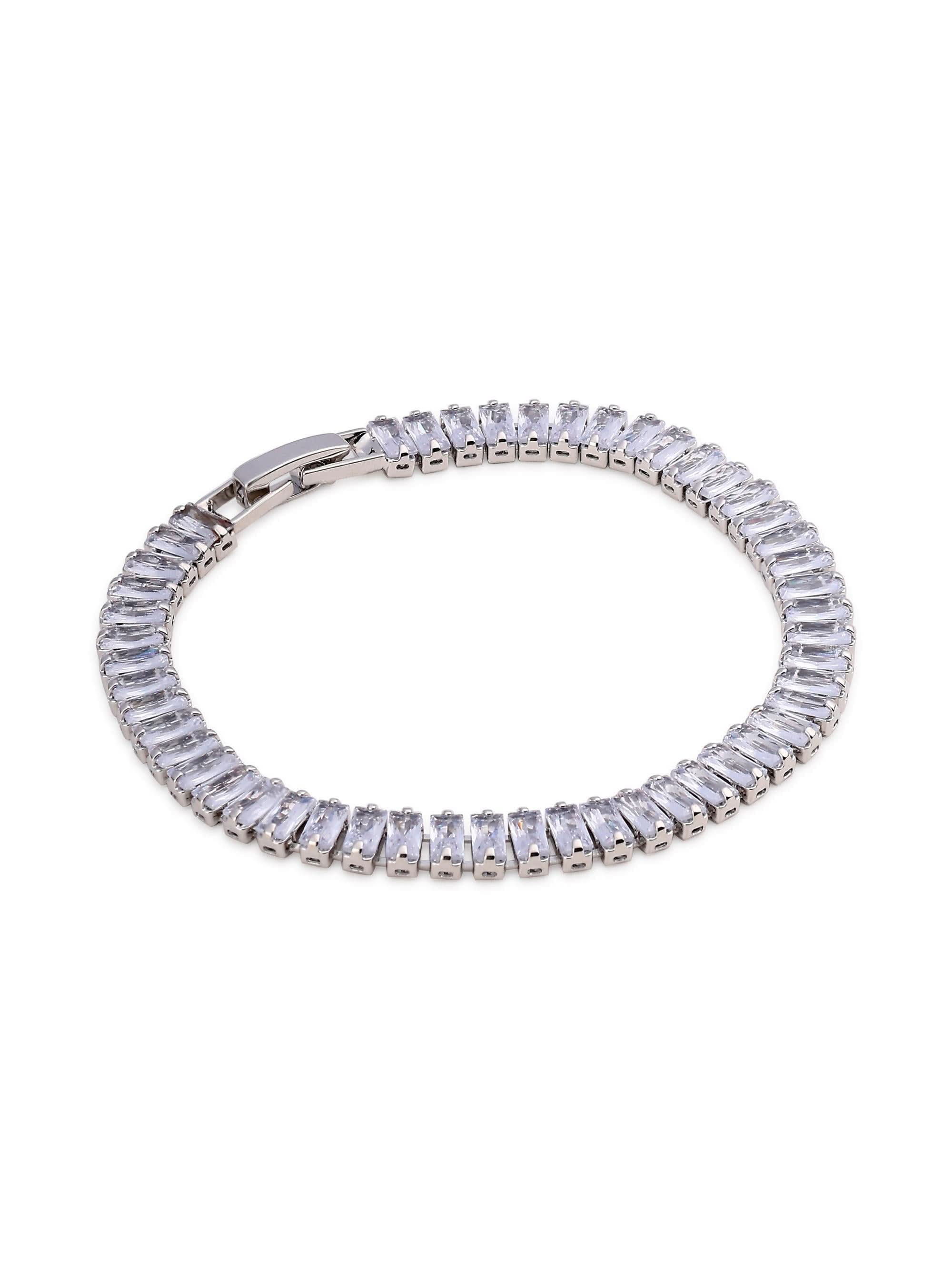Flat-lay of silver tennis bracelet with baguette-cut crystals and box clasp