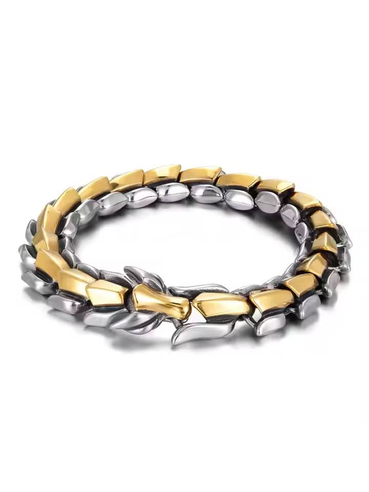 Flat-lay of two-tone silver and gold dragon bracelet with dragon head clasp