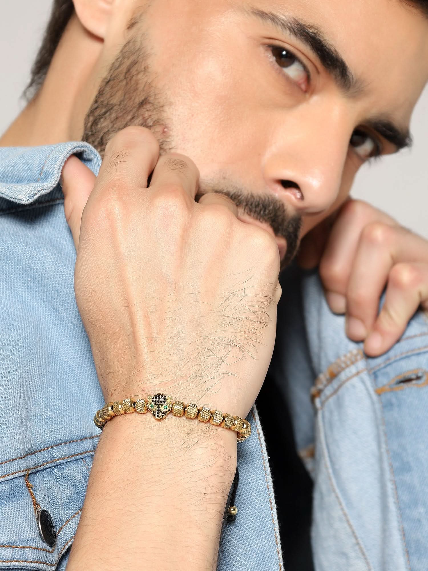 Man in denim jacket wearing Jewelor gold leopard bracelet stack on his wrist