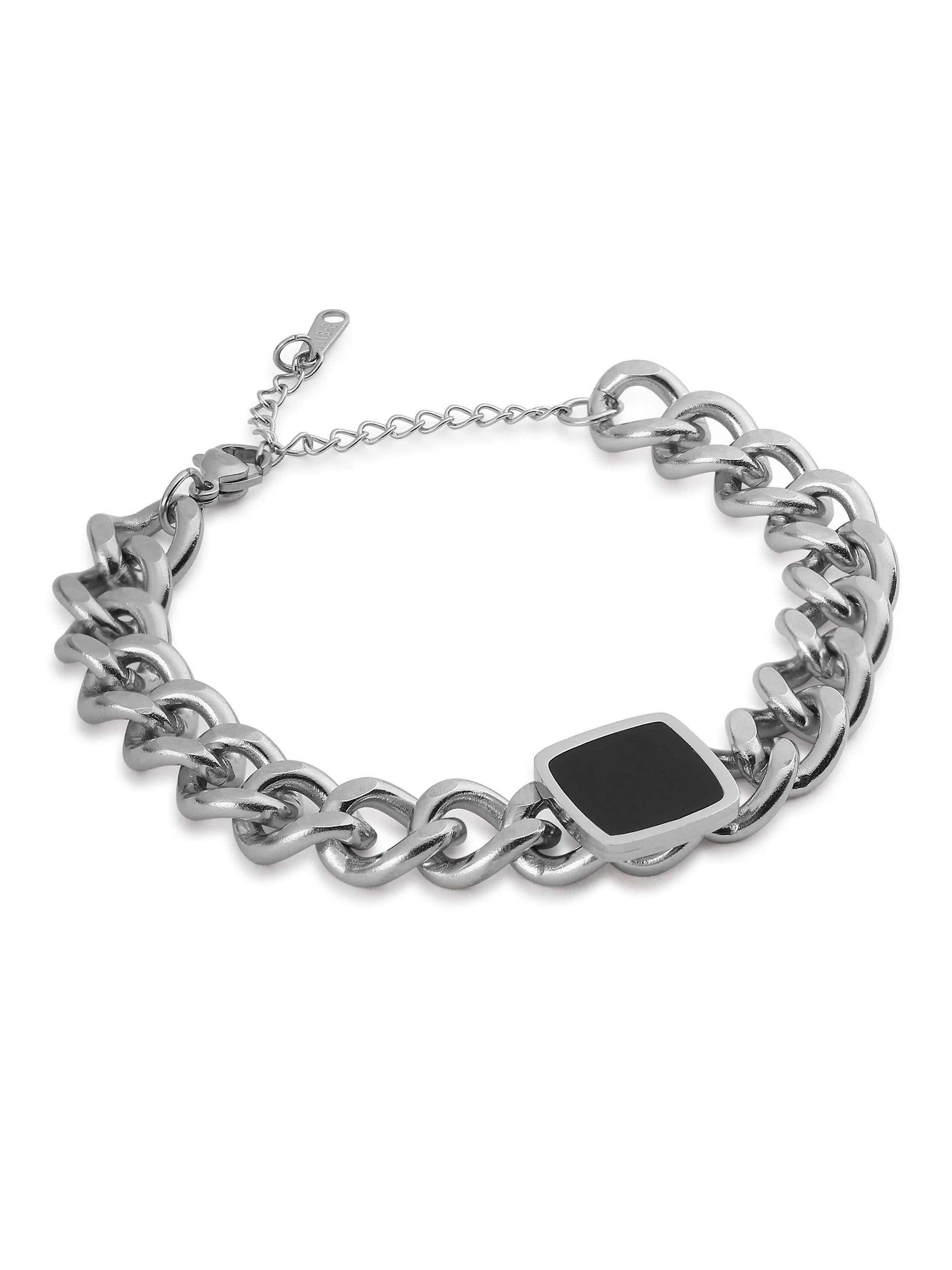 Flat-lay of silver curb chain bracelet with black square centerpiece and extender chain