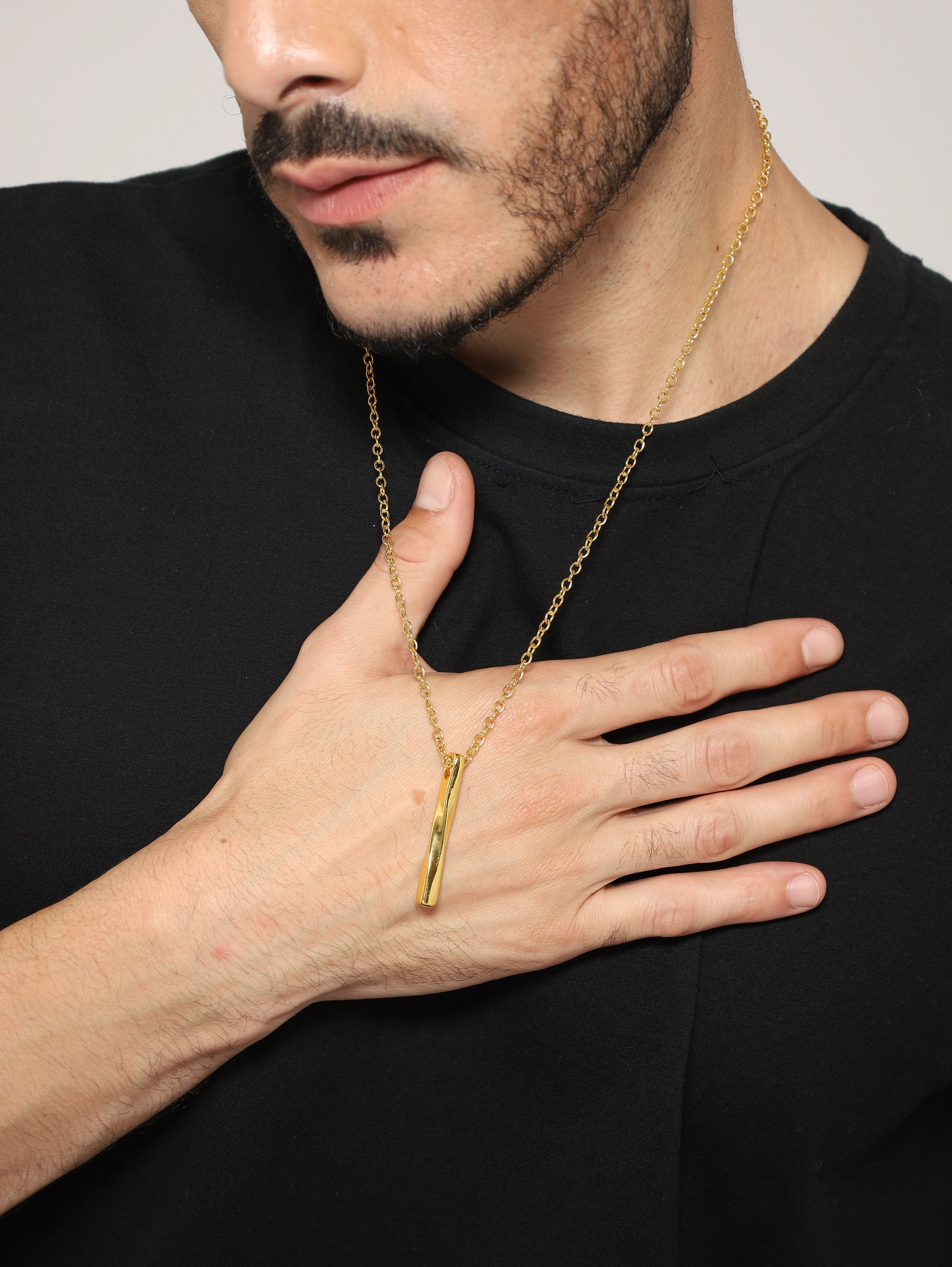 Model wearing Twisted Long Vertical Bar Pendant in gold — men's gold pendant styled on hand