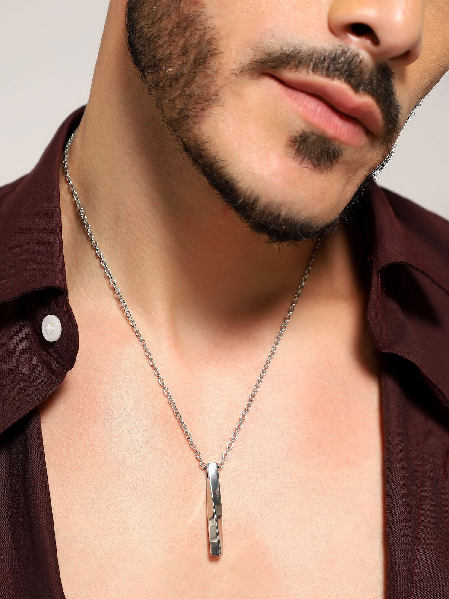 Model wearing Twisted Long Vertical Bar Pendant in silver — men's silver pendant styled on hand