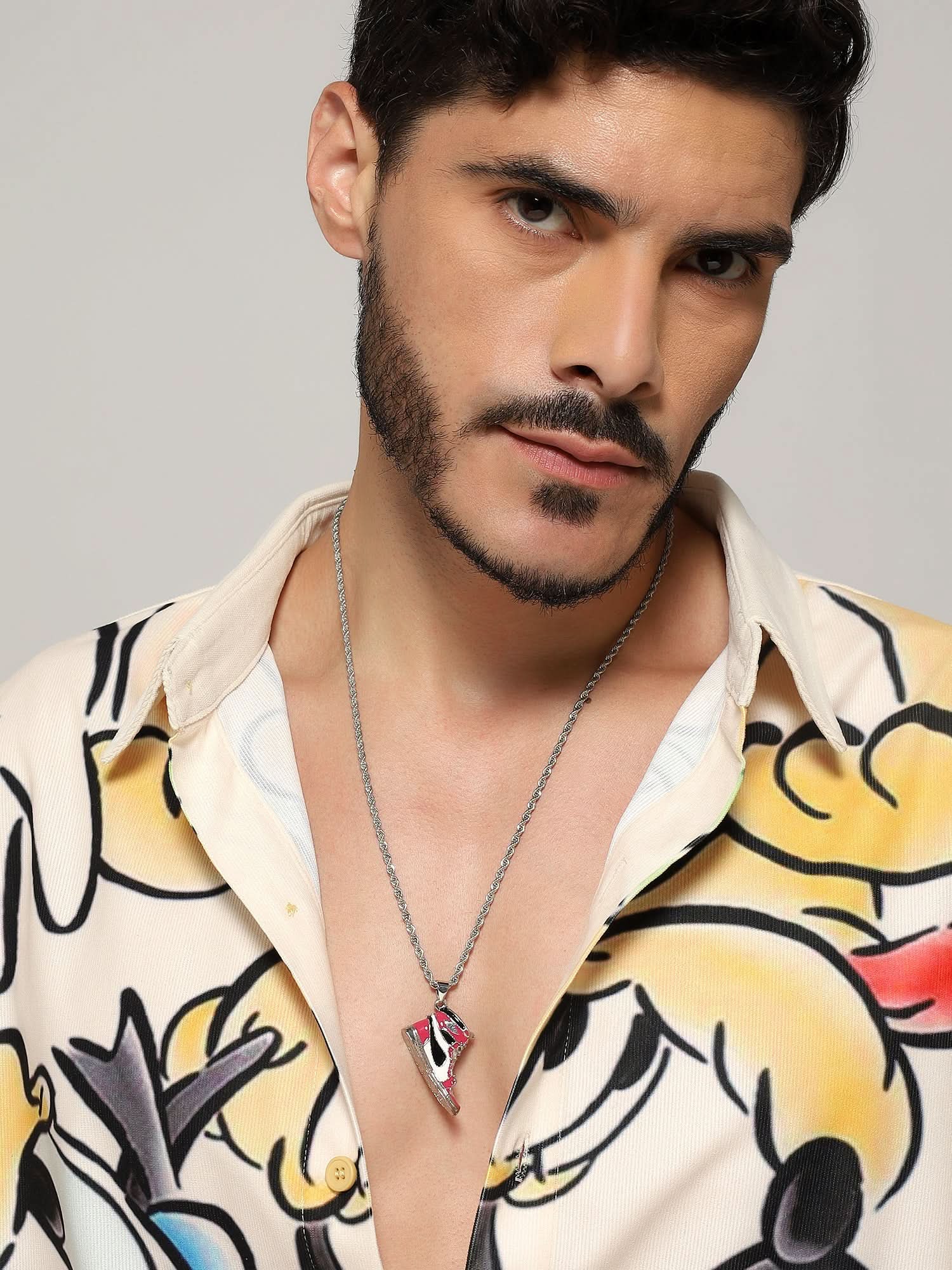 Model wearing Sneaker Pendant in red — men's red pendant styled on hand