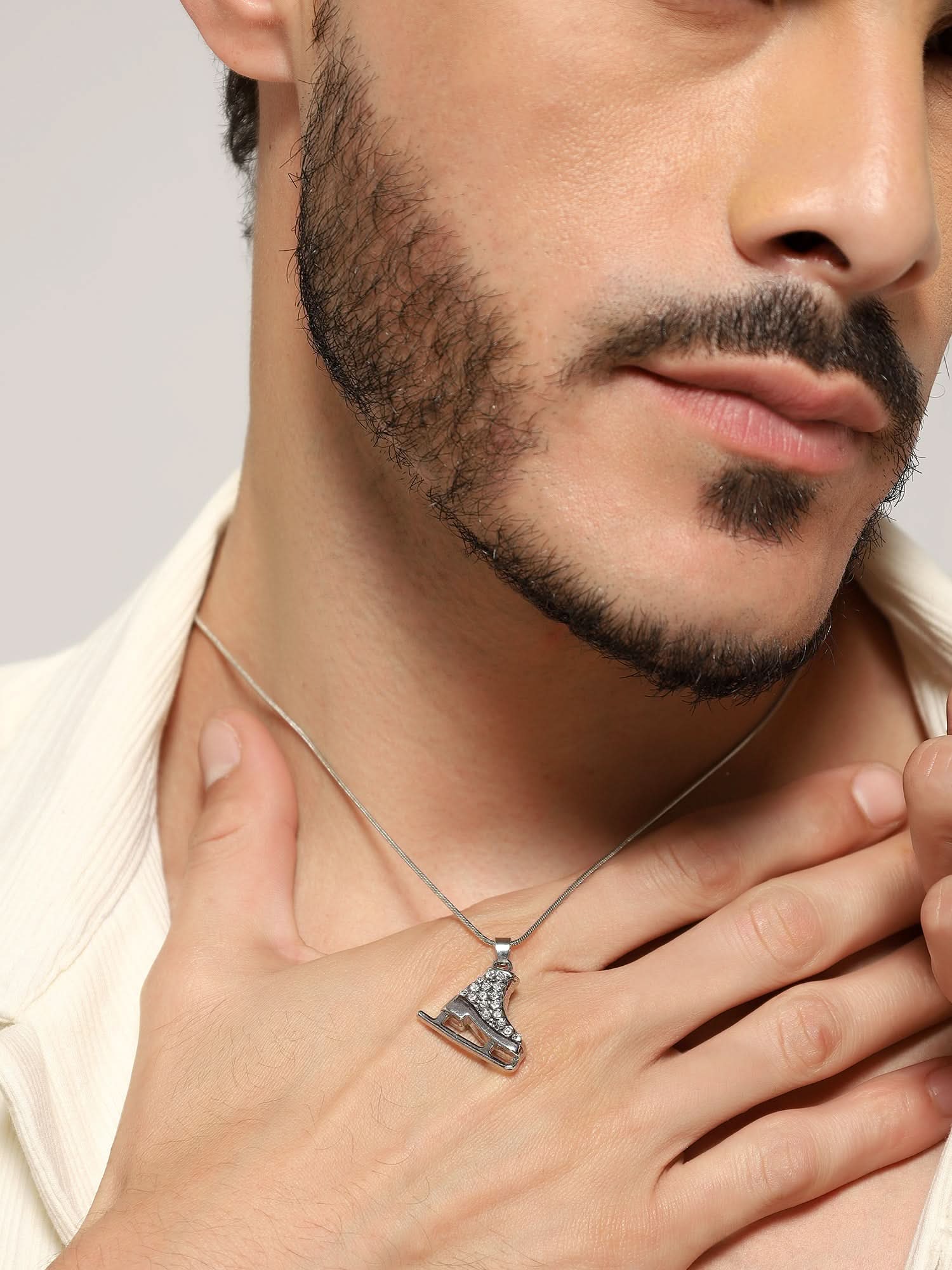 Model wearing Zircon Skate Pendant in silver — men's silver pendant styled on hand