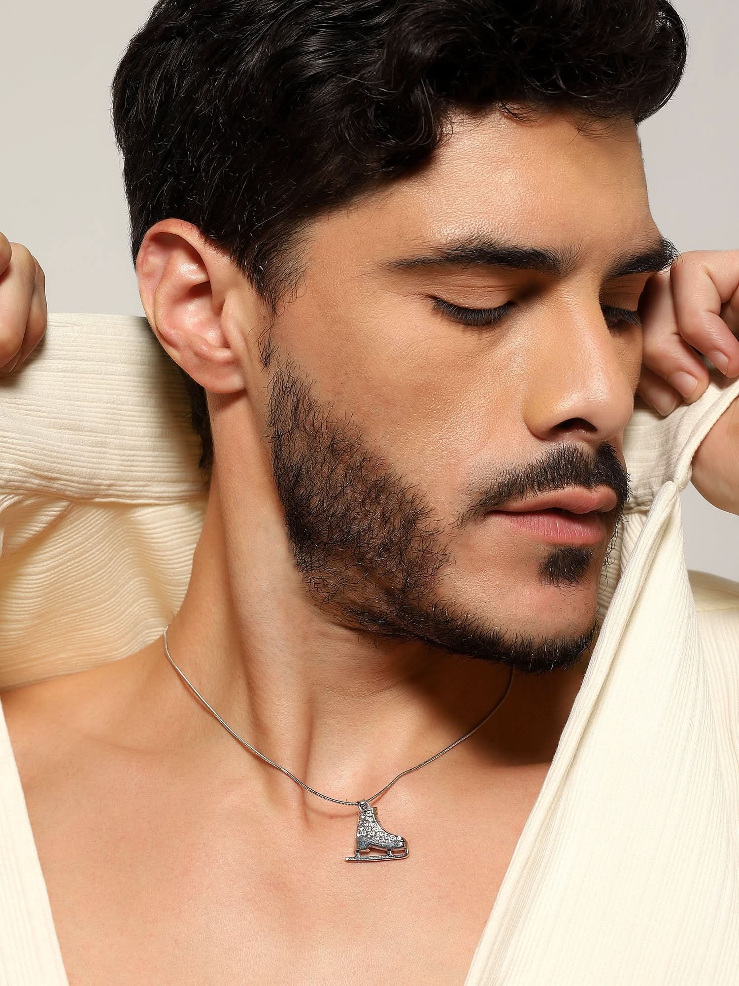 Model wearing Zircon Skate Pendant in silver — men's silver pendant styled on hand