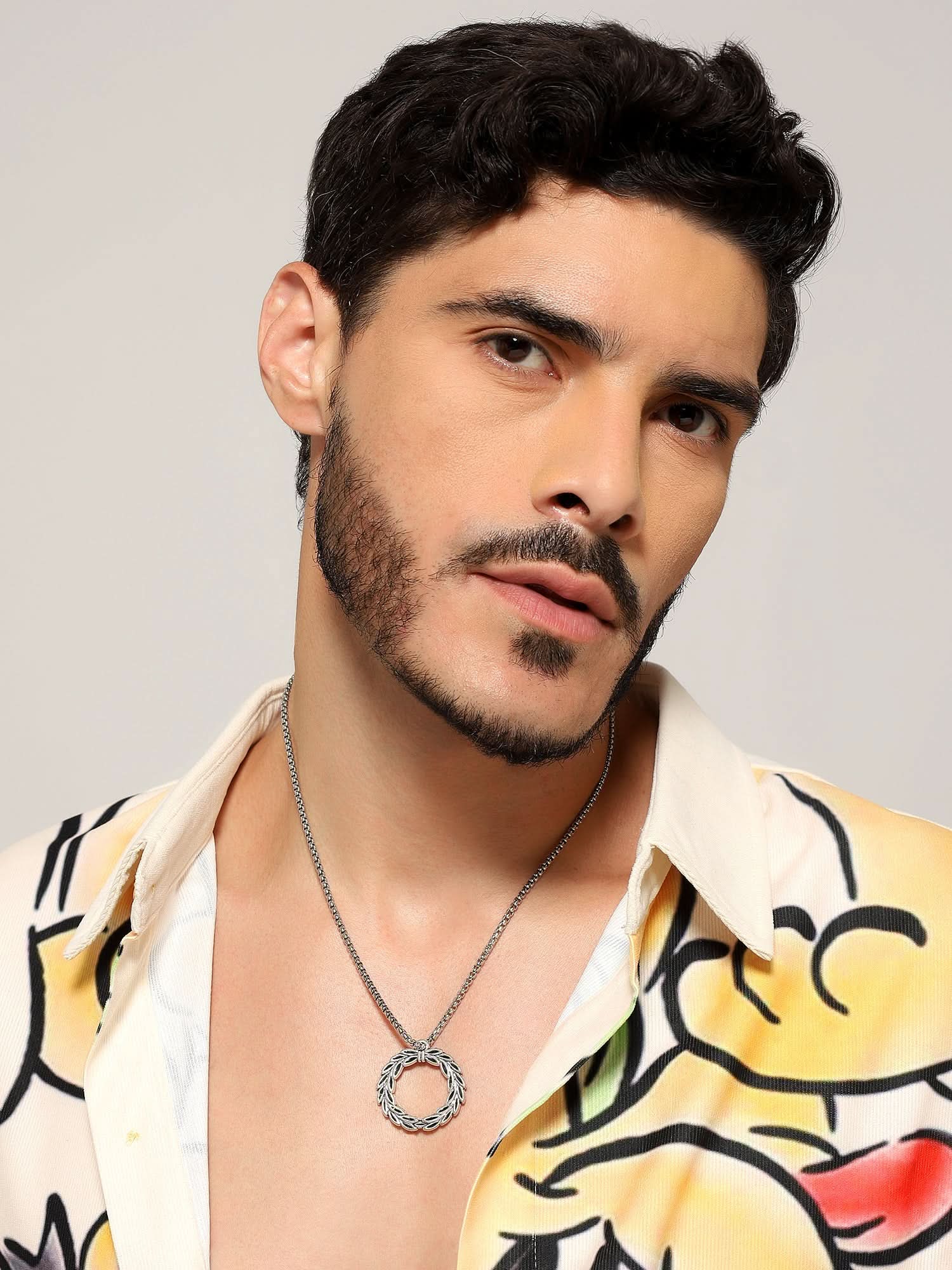 Model wearing Peace Olive Pendant in silver — men's silver pendant styled on hand