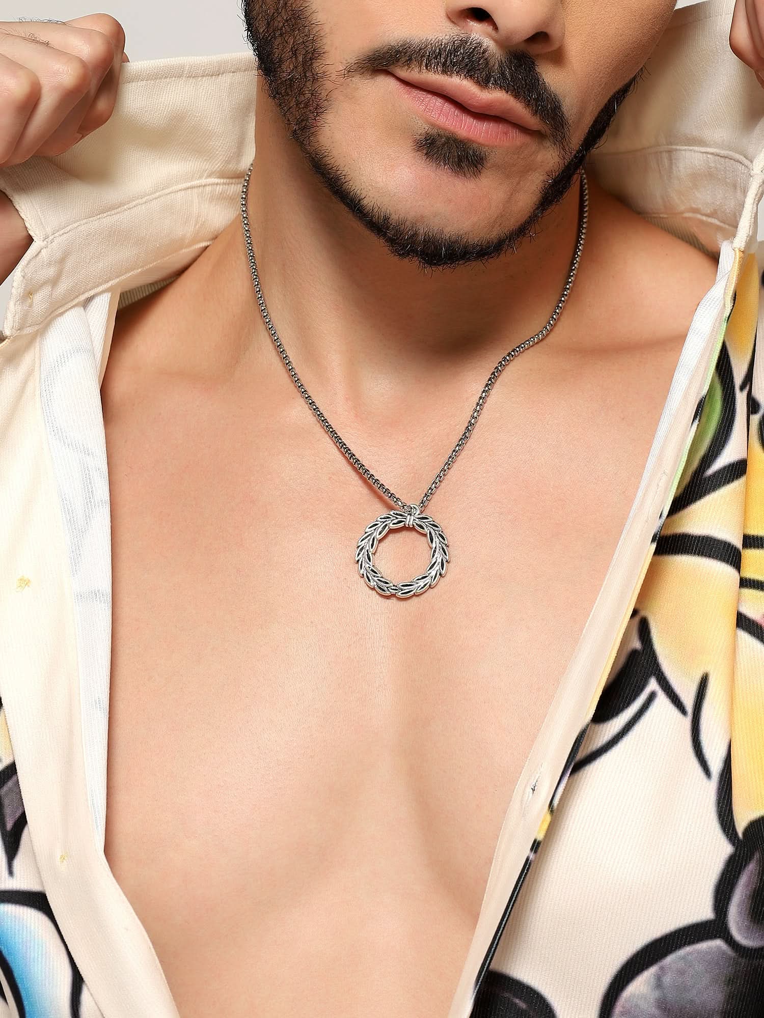 Model wearing Peace Olive Pendant in silver — men's silver pendant styled on hand