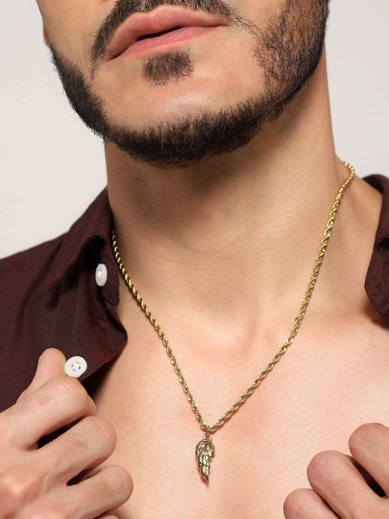 Model wearing Cupid Angel Wing Pendant in gold — men's gold pendant styled on hand
