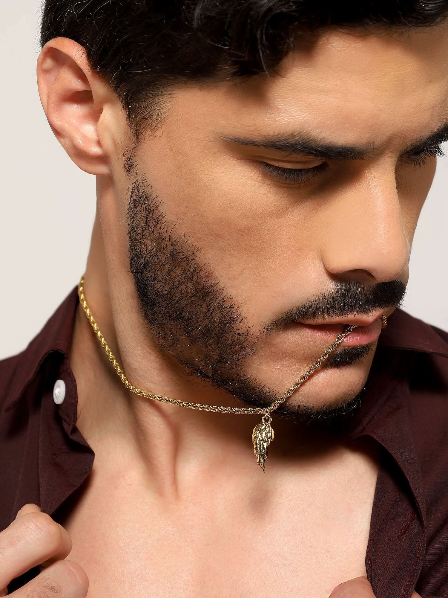 Model wearing Cupid Angel Wing Pendant in gold — men's gold pendant styled on hand