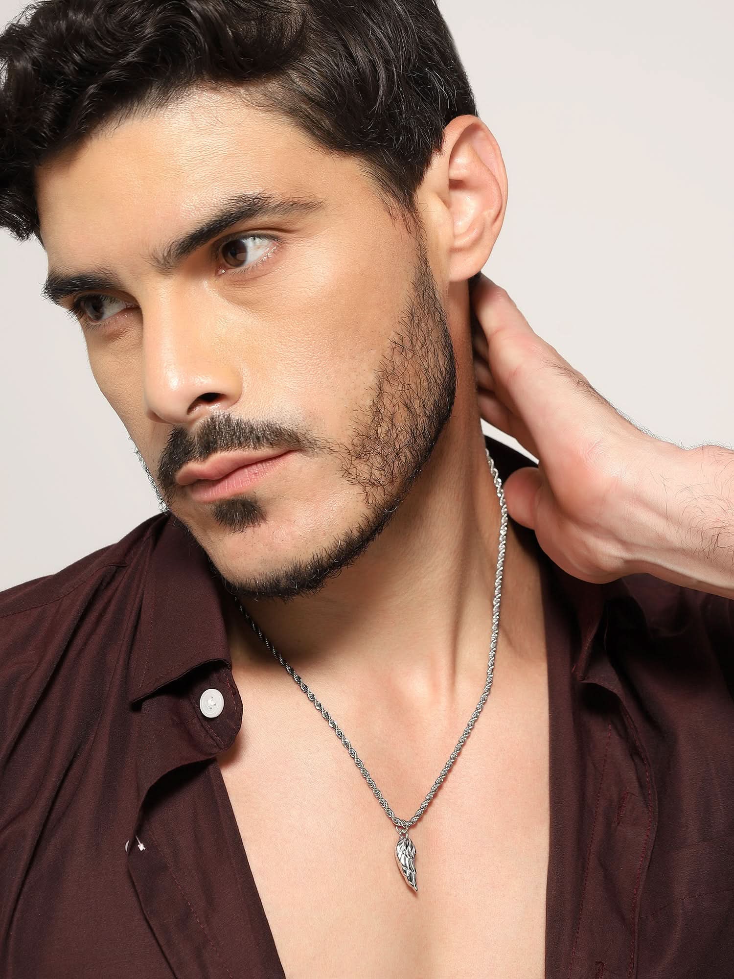 Model wearing Cupid Angel Wing Pendant in silver — men's silver pendant styled on hand