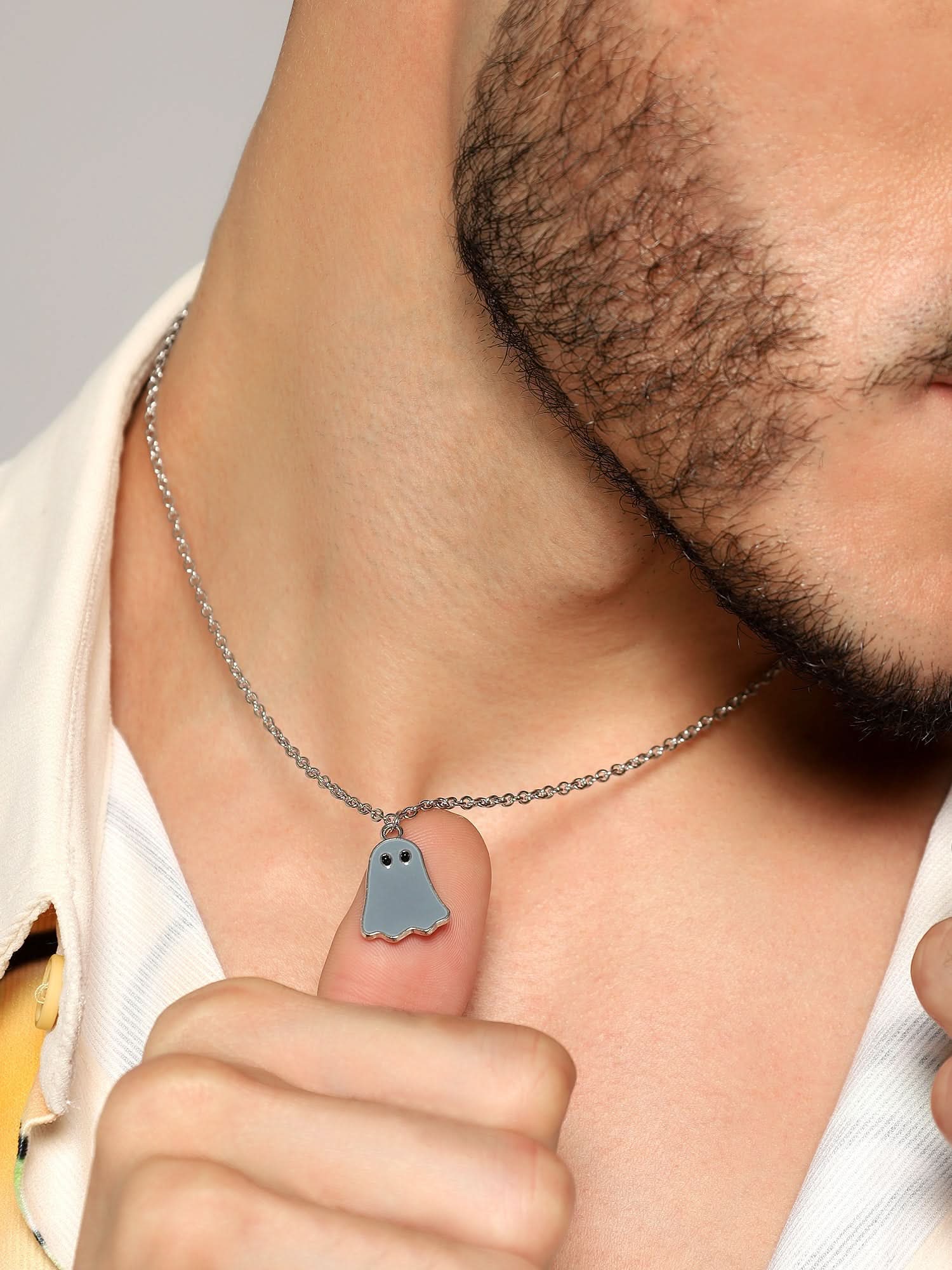Model wearing Halloween Cute Cartoon Ghost Pendant in grey — men's grey pendant styled on hand