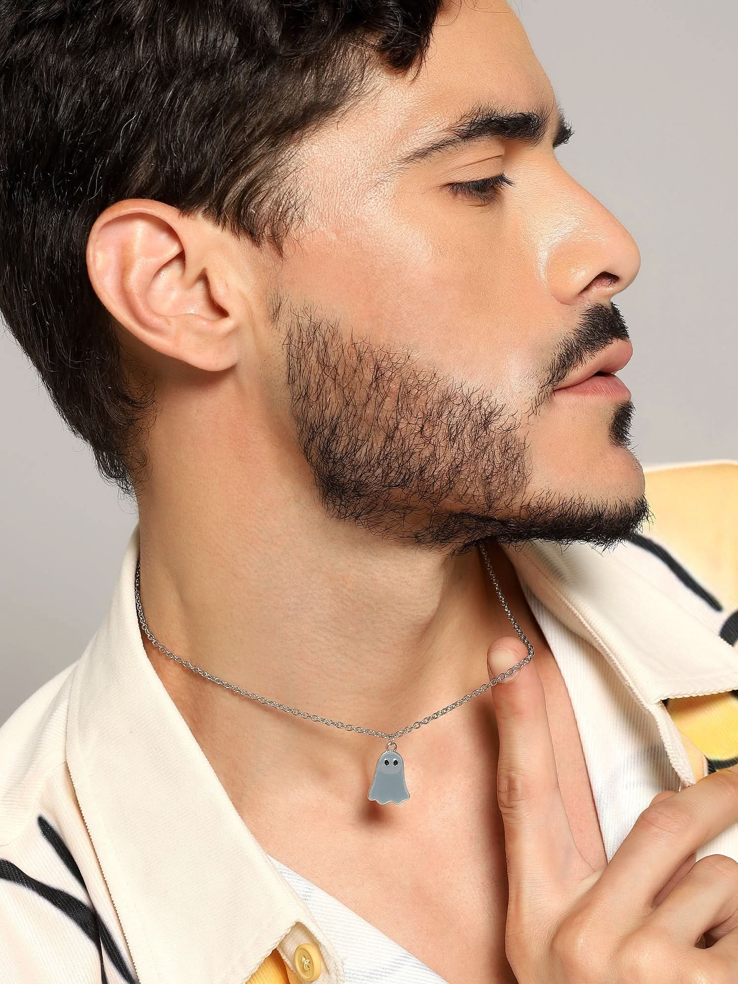 Model wearing Halloween Cute Cartoon Ghost Pendant in grey — men's grey pendant styled on hand