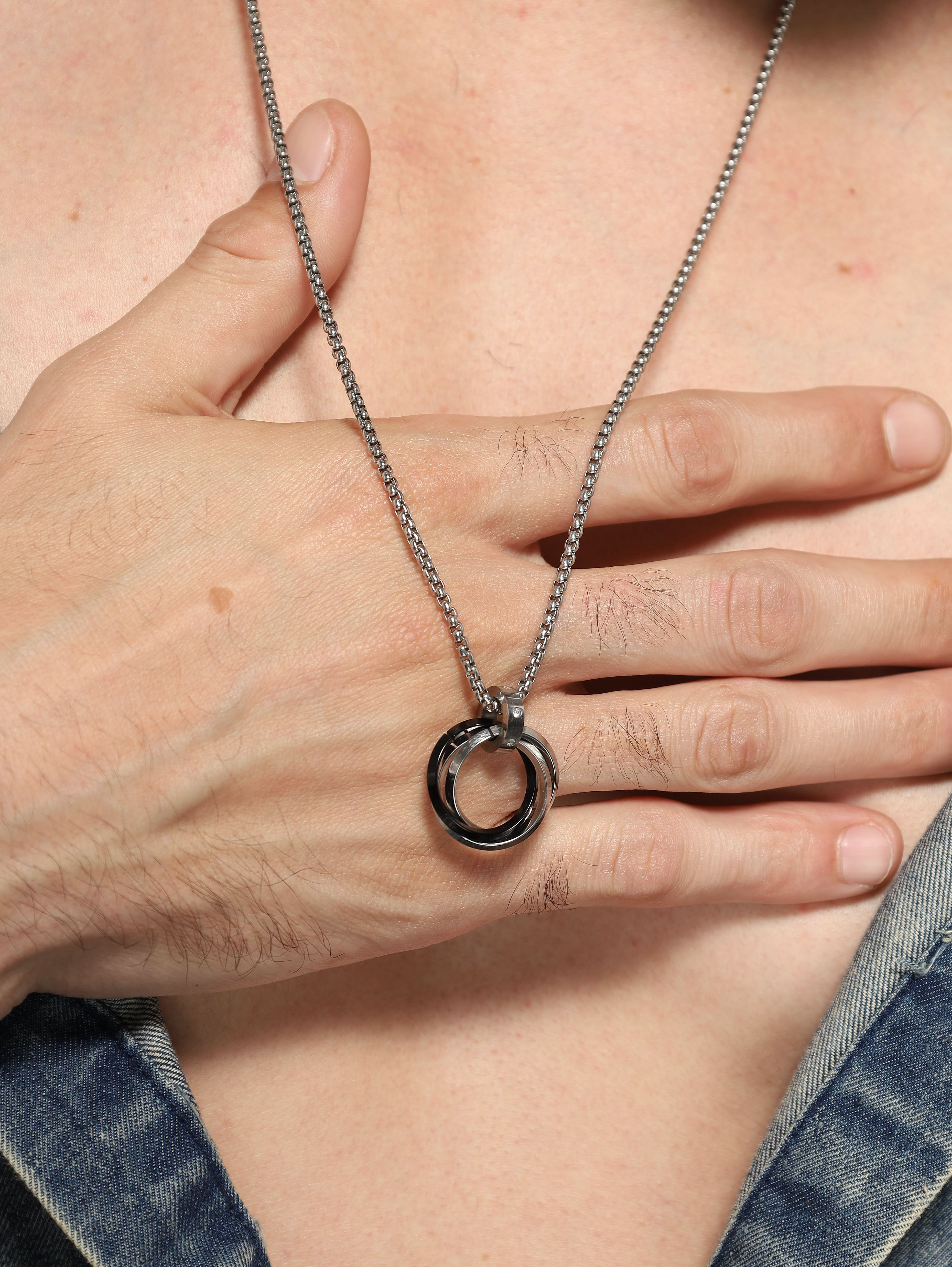 Model wearing Three Rings Round Circle Pendant in black — men's black pendant styled on hand