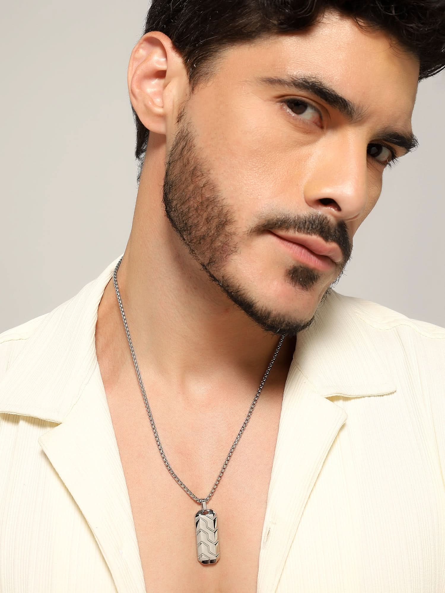 Model wearing Hexagonal 3D Diagonal Tire Pendant in silver — men's silver pendant styled on hand