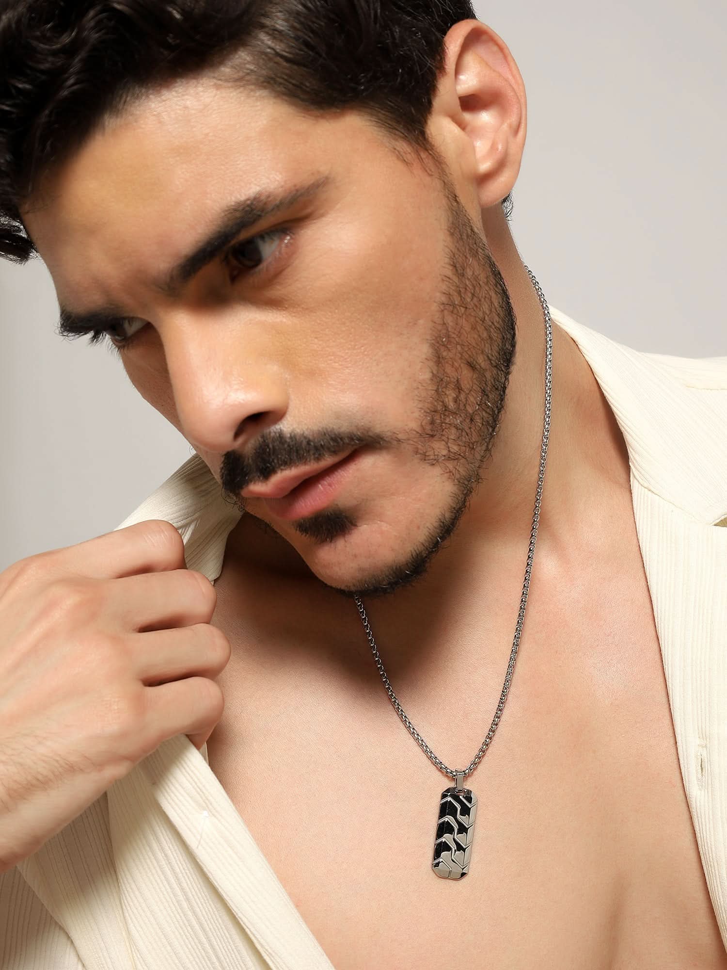 Model wearing Hexagonal 3D Diagonal Tire Pendant in silver — men's silver pendant styled on hand