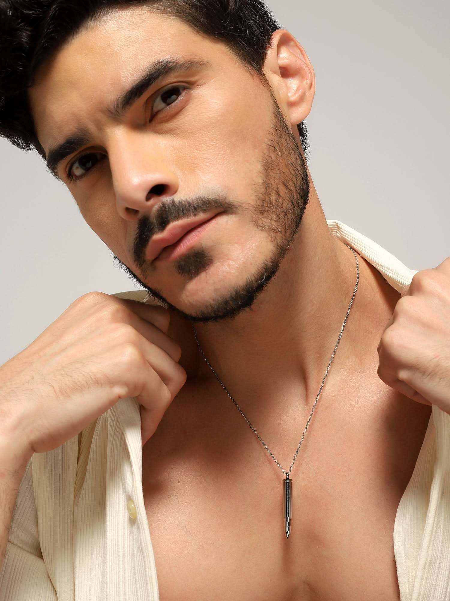 Model wearing Bullet Head Pendant in silver — men's silver pendant styled on hand