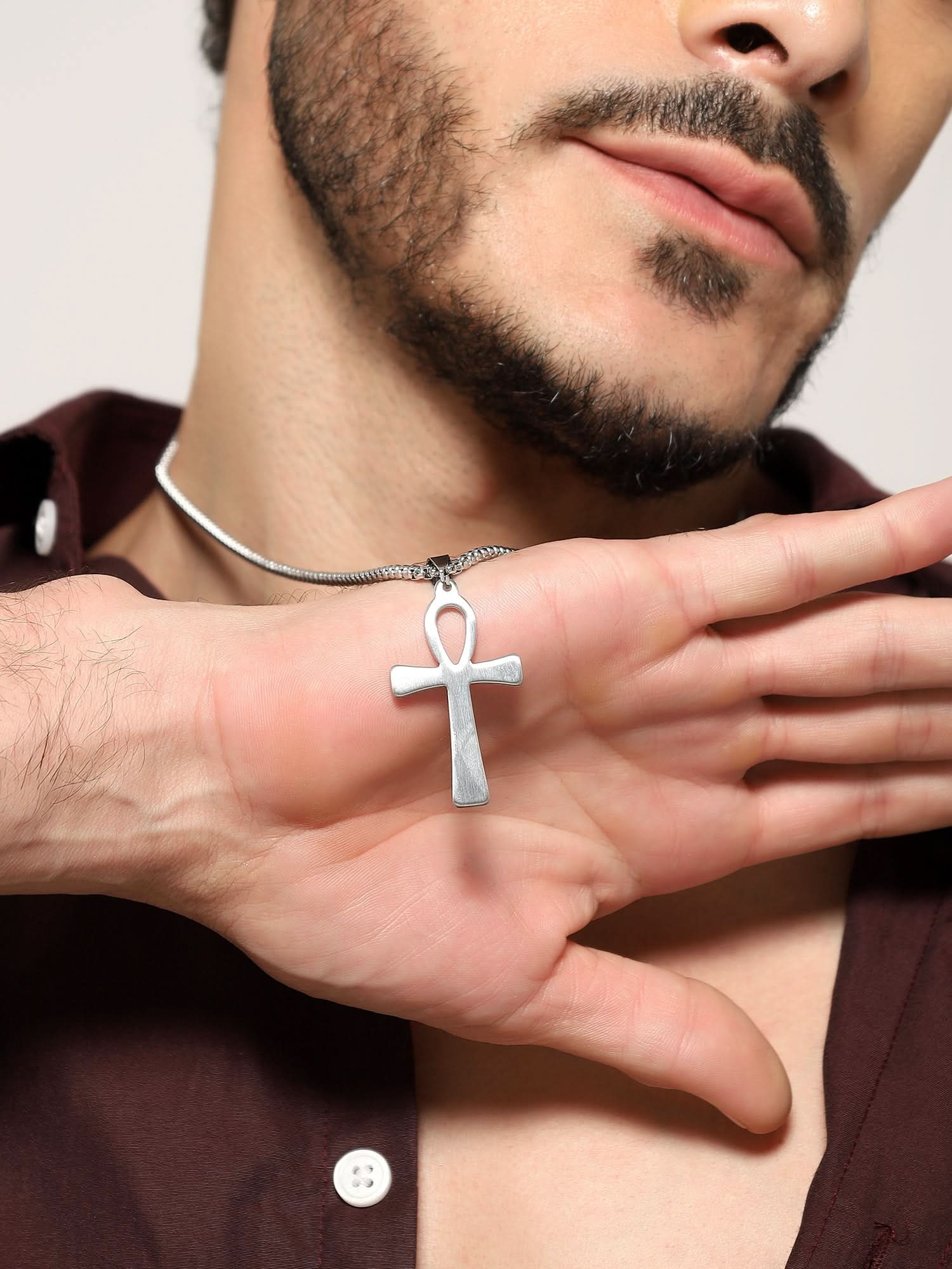 Model wearing Egyptian Eye Crucifix Cross Pendant in silver — men's silver pendant styled on hand