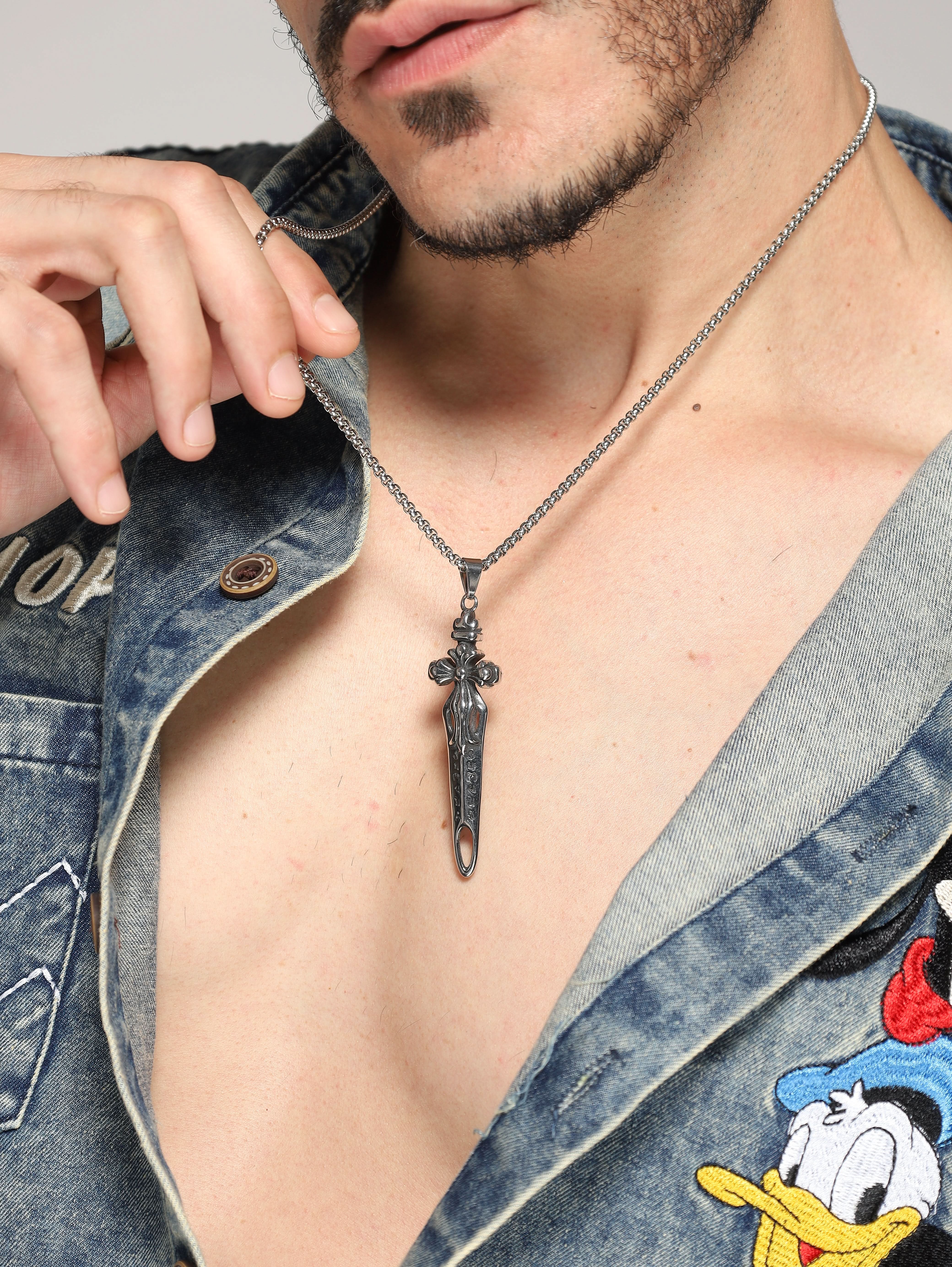 Model wearing Sword Pendant in silver — men's silver pendant styled on hand