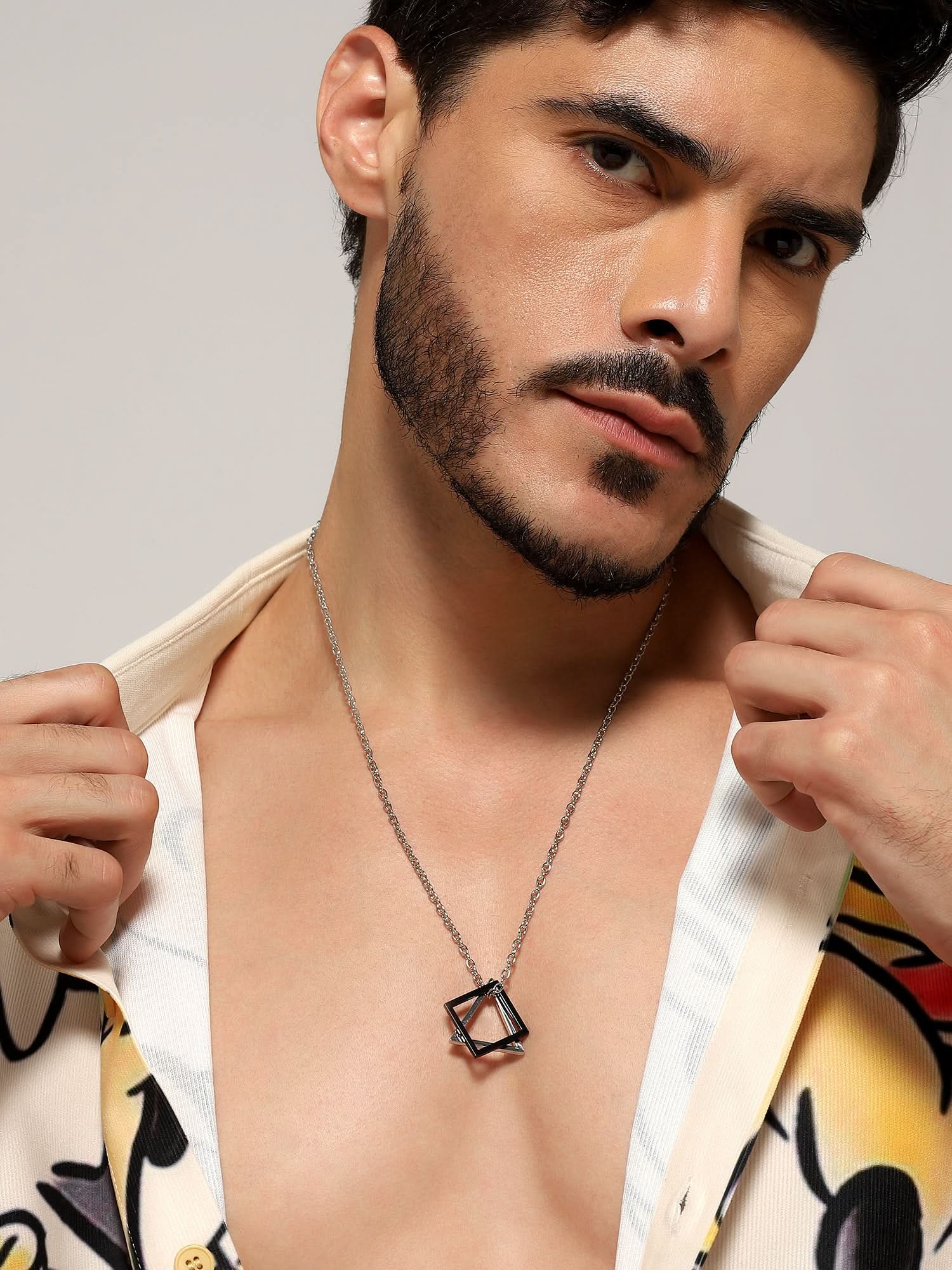 Model wearing Square Triangle Designer Pendant in silver black — men's silver black pendant styled on hand