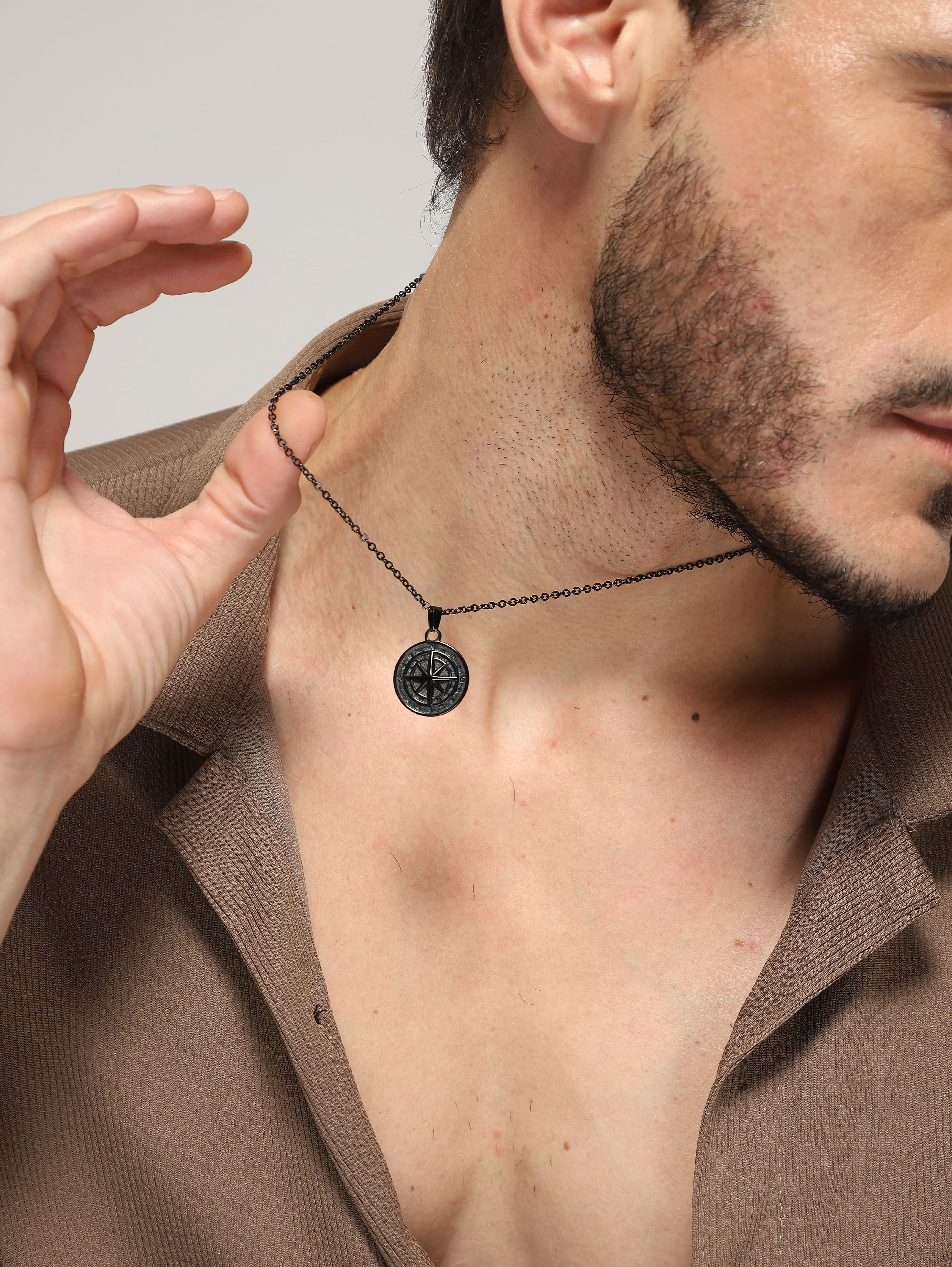 Model wearing North Star Pendant in black — men's black pendant styled on hand