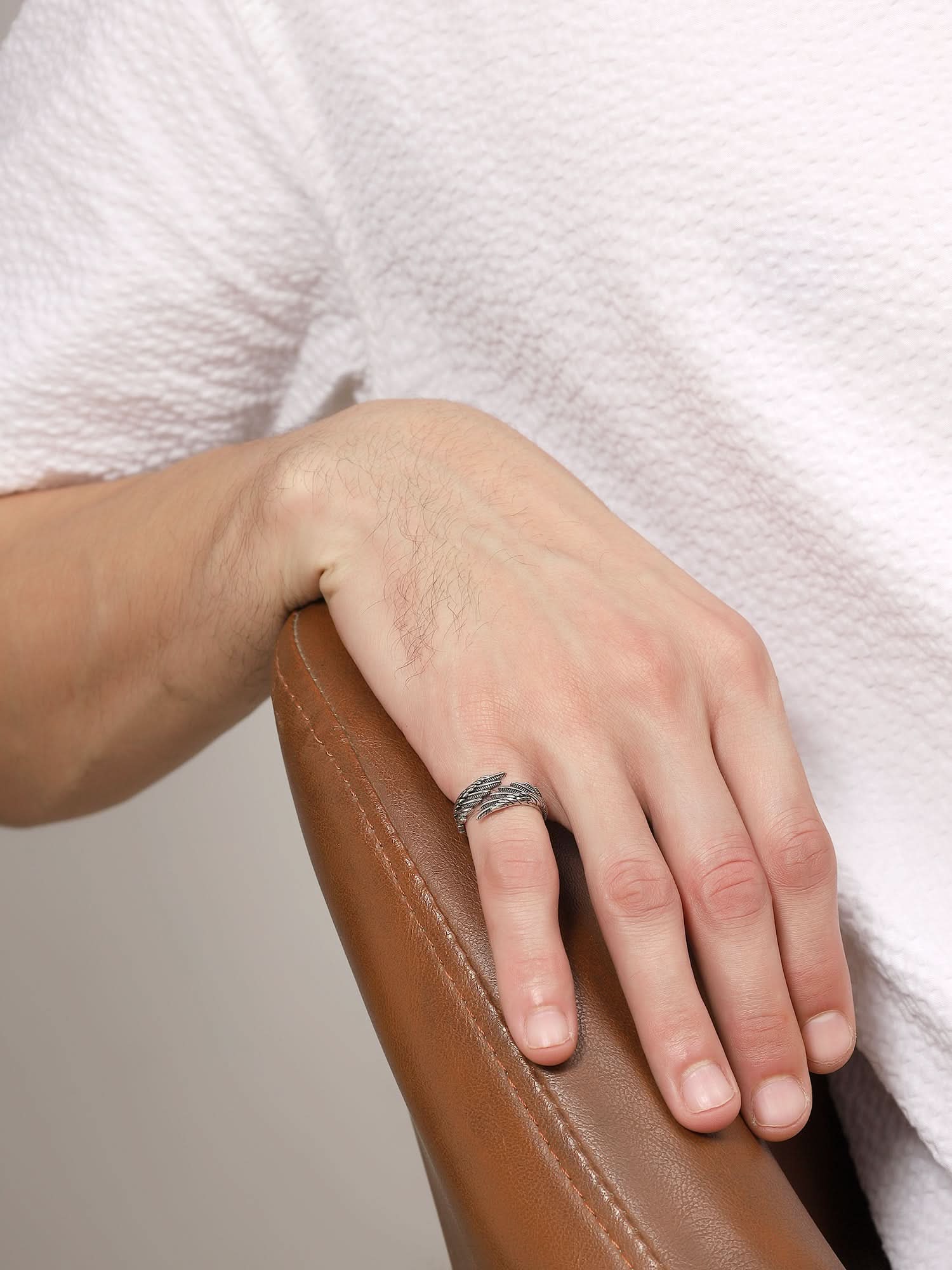 Model wearing Old Feather Ring in silver — men's silver ring styled on hand