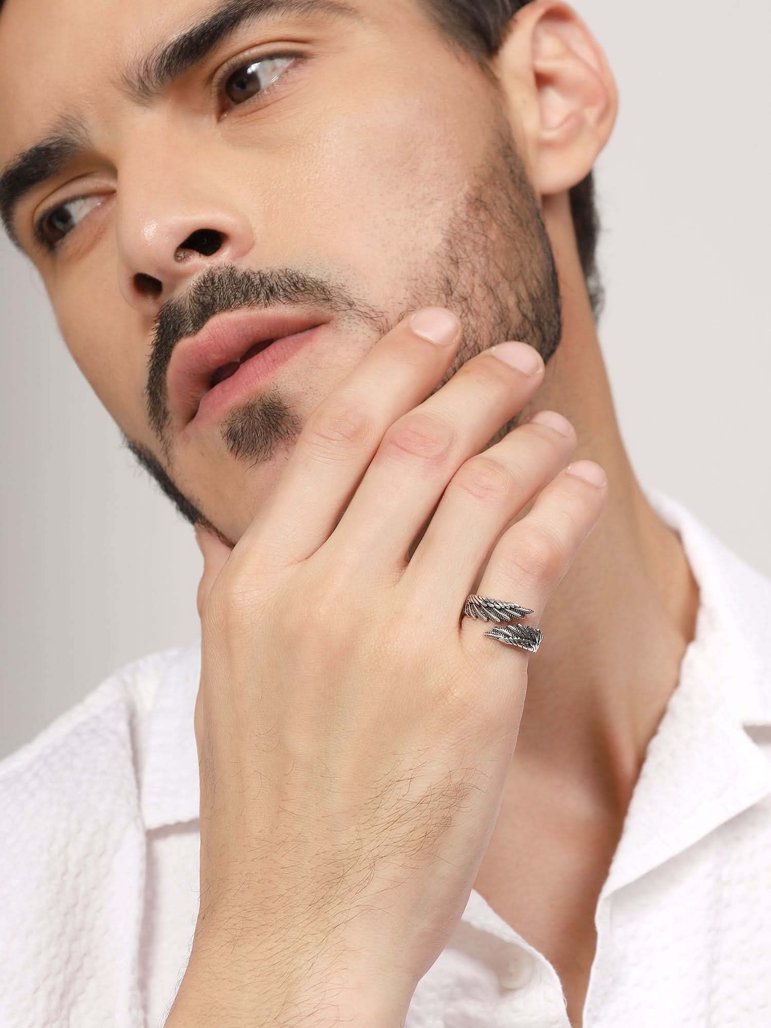 Model wearing Old Feather Ring in silver — men's silver ring styled on hand