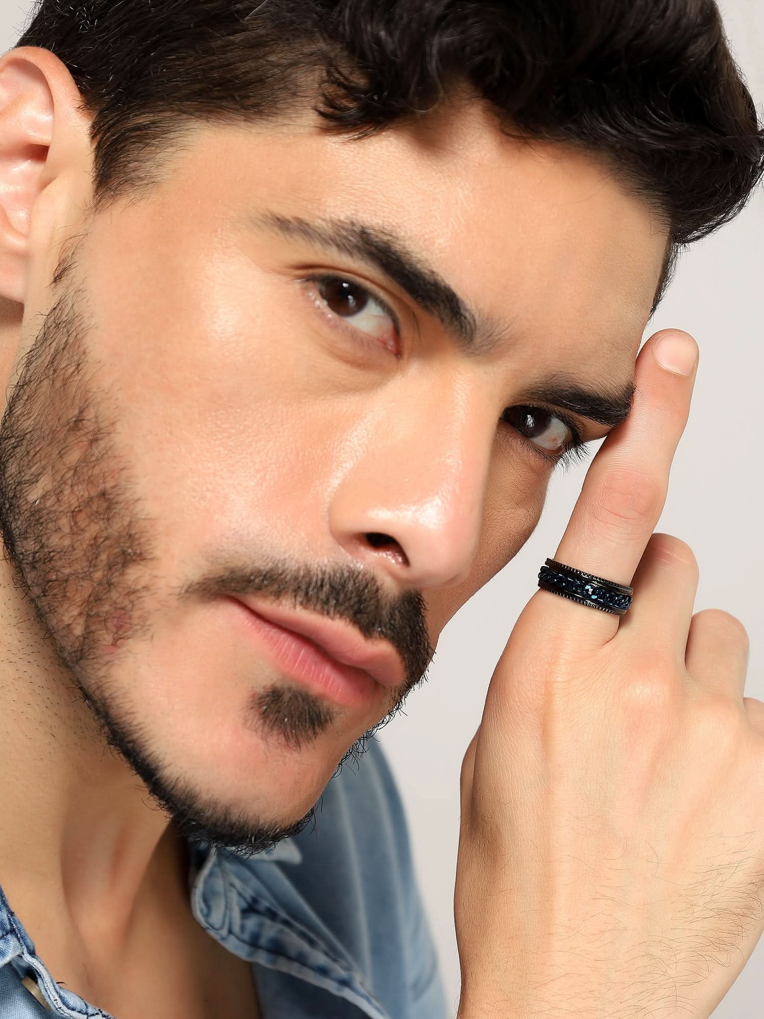Model wearing Open Bottle Spinner Ring in blue black — men's blue black ring styled on hand