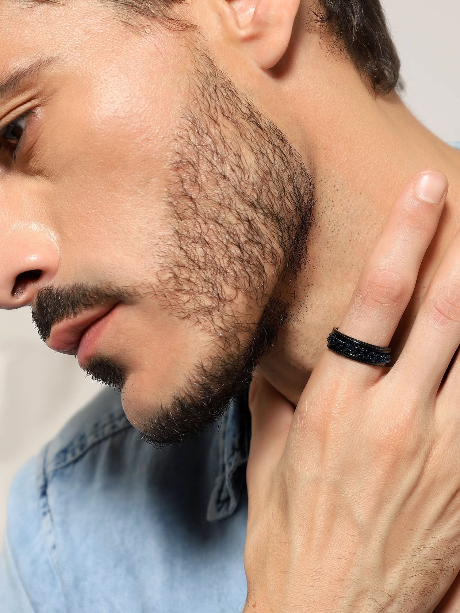 Model wearing Open Bottle Spinner Ring in blue black — men's blue black ring styled on hand