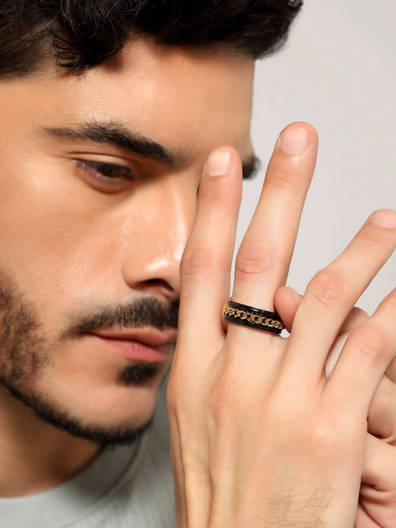 Model wearing Open Bottle Spinner Ring in gold black — men's gold black ring styled on hand
