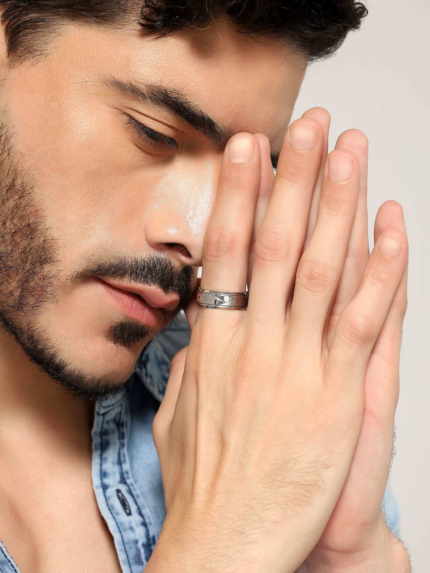 Model wearing Crisscross Ring in silver — men's silver ring styled on hand
