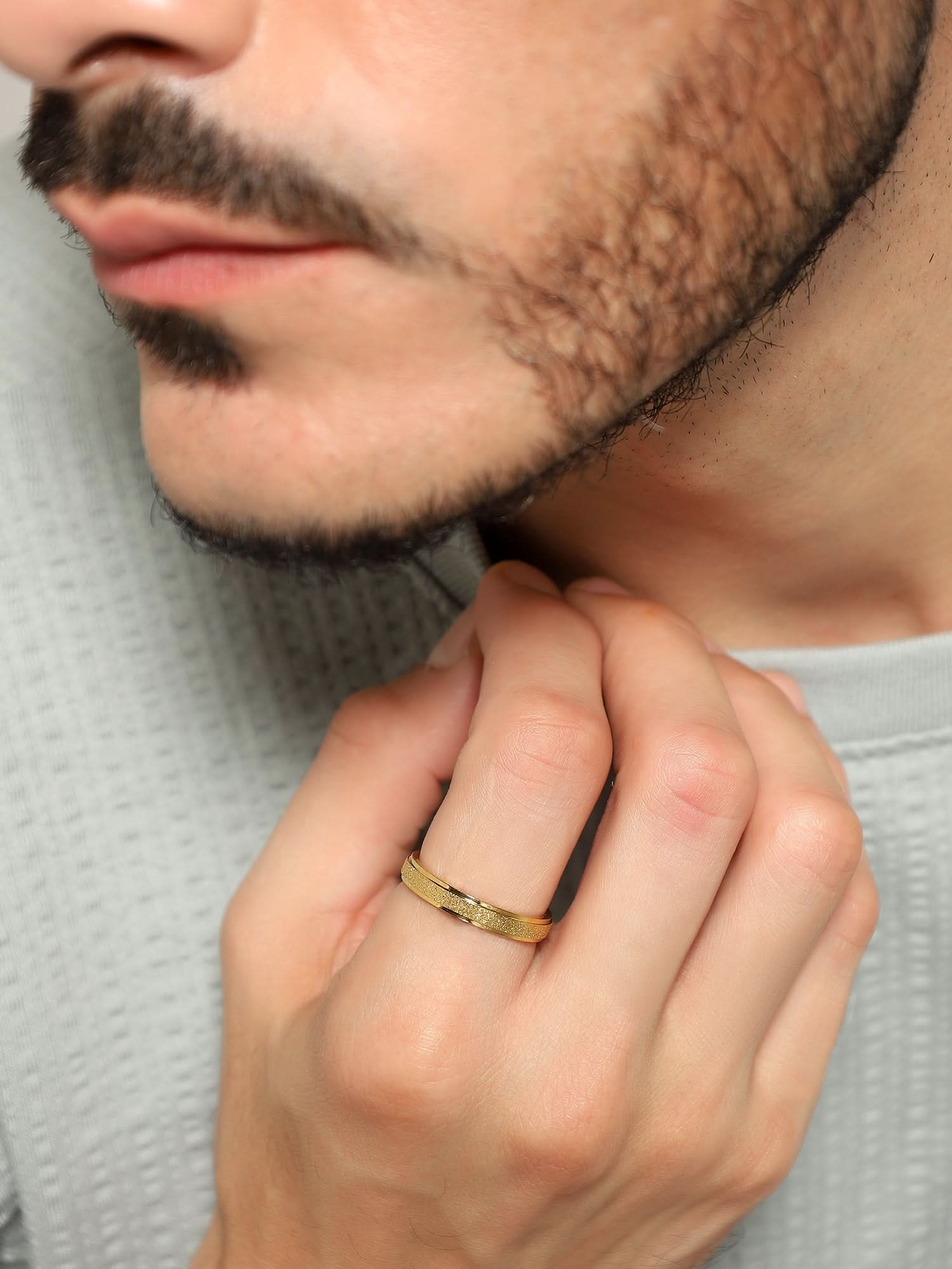 Model wearing Glitty Trose Embossed Ring in gold — men's gold ring styled on hand