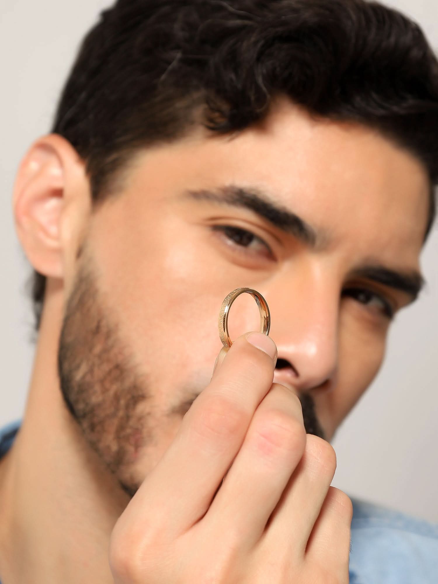Model wearing Glitty Trose Embossed Ring in rose gold — men's rose gold ring styled on hand