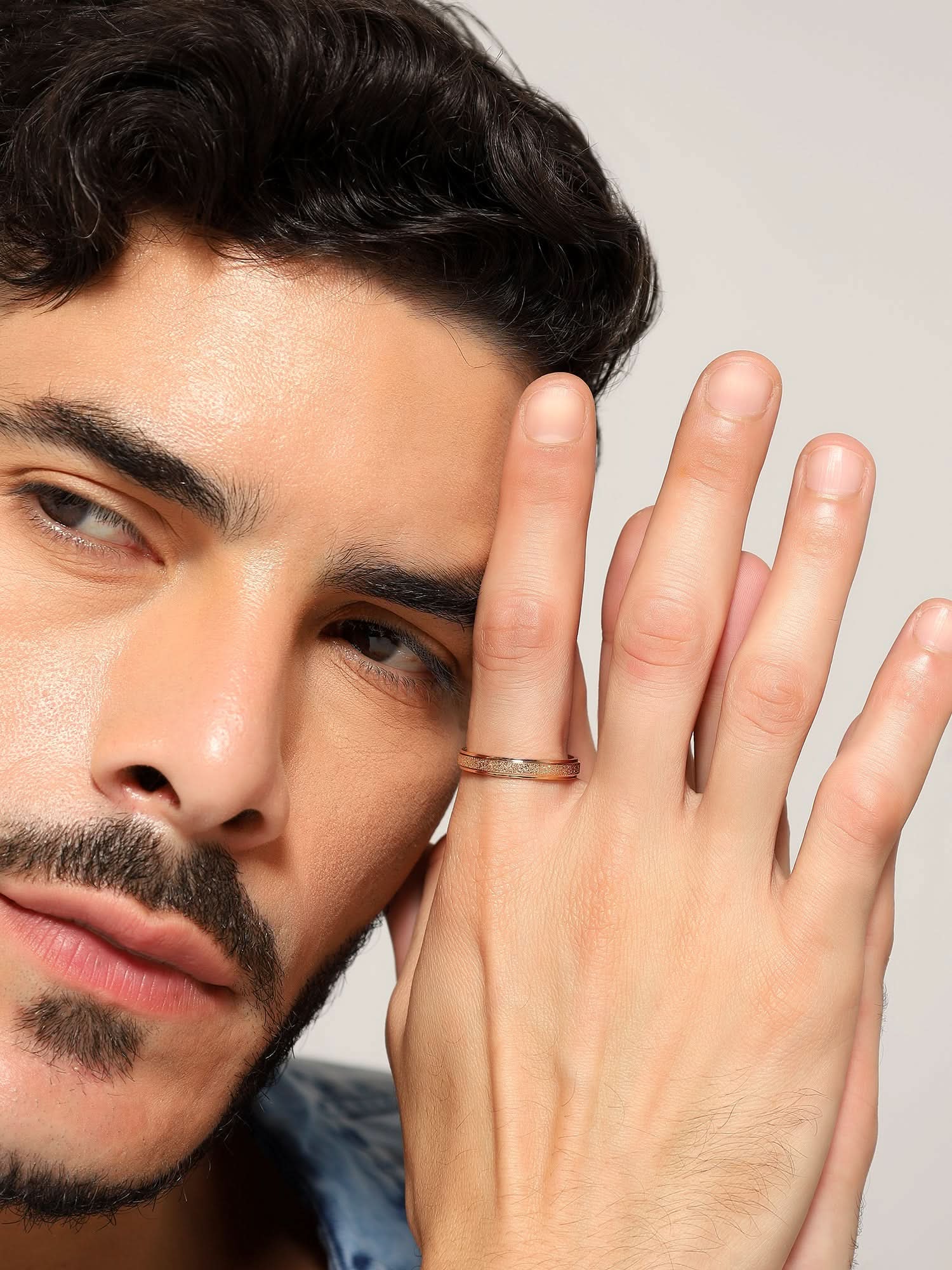 Model wearing Glitty Trose Embossed Ring in rose gold — men's rose gold ring styled on hand