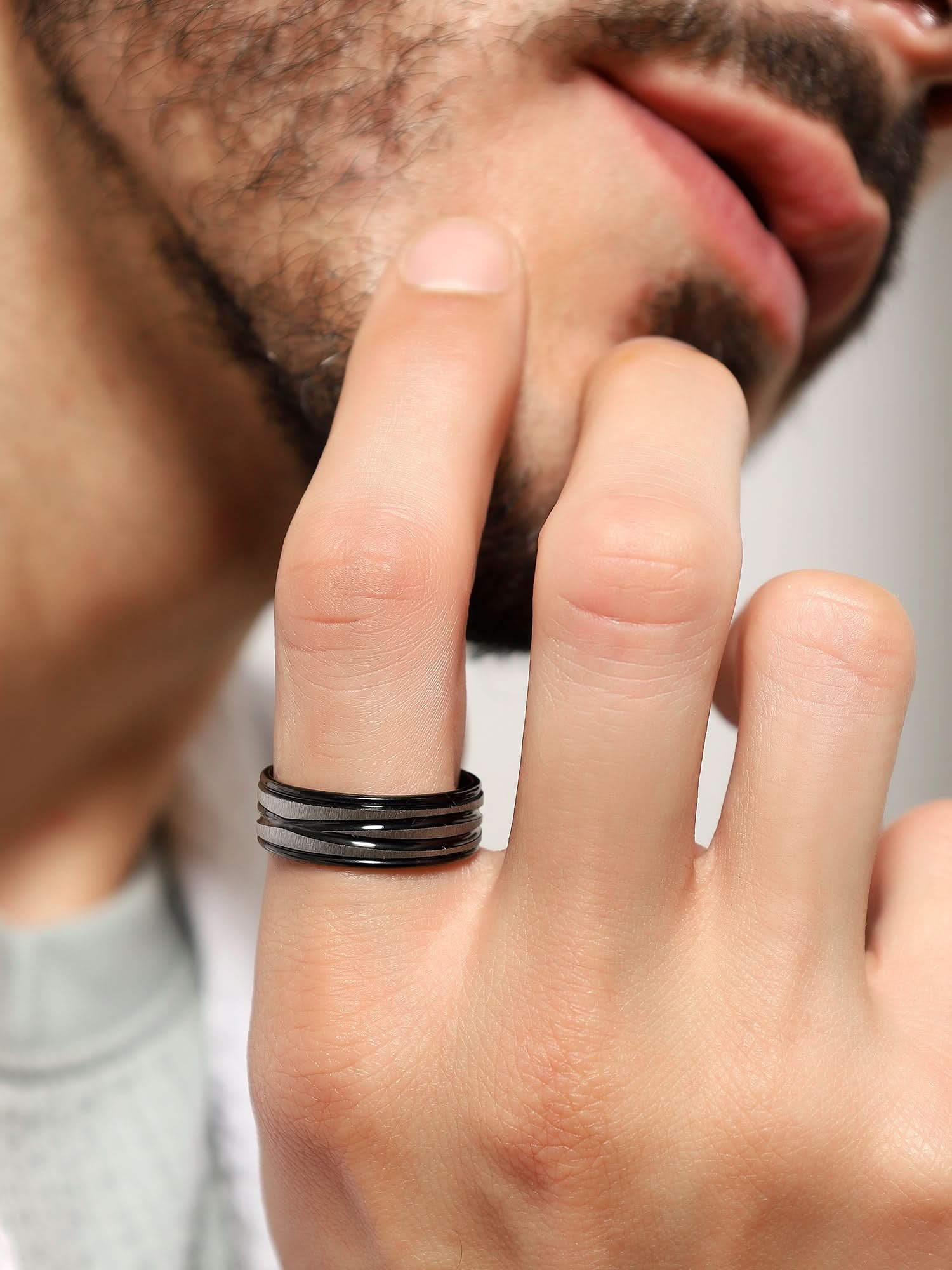 Model wearing Crossover Line Ring in black — men's black ring styled on hand