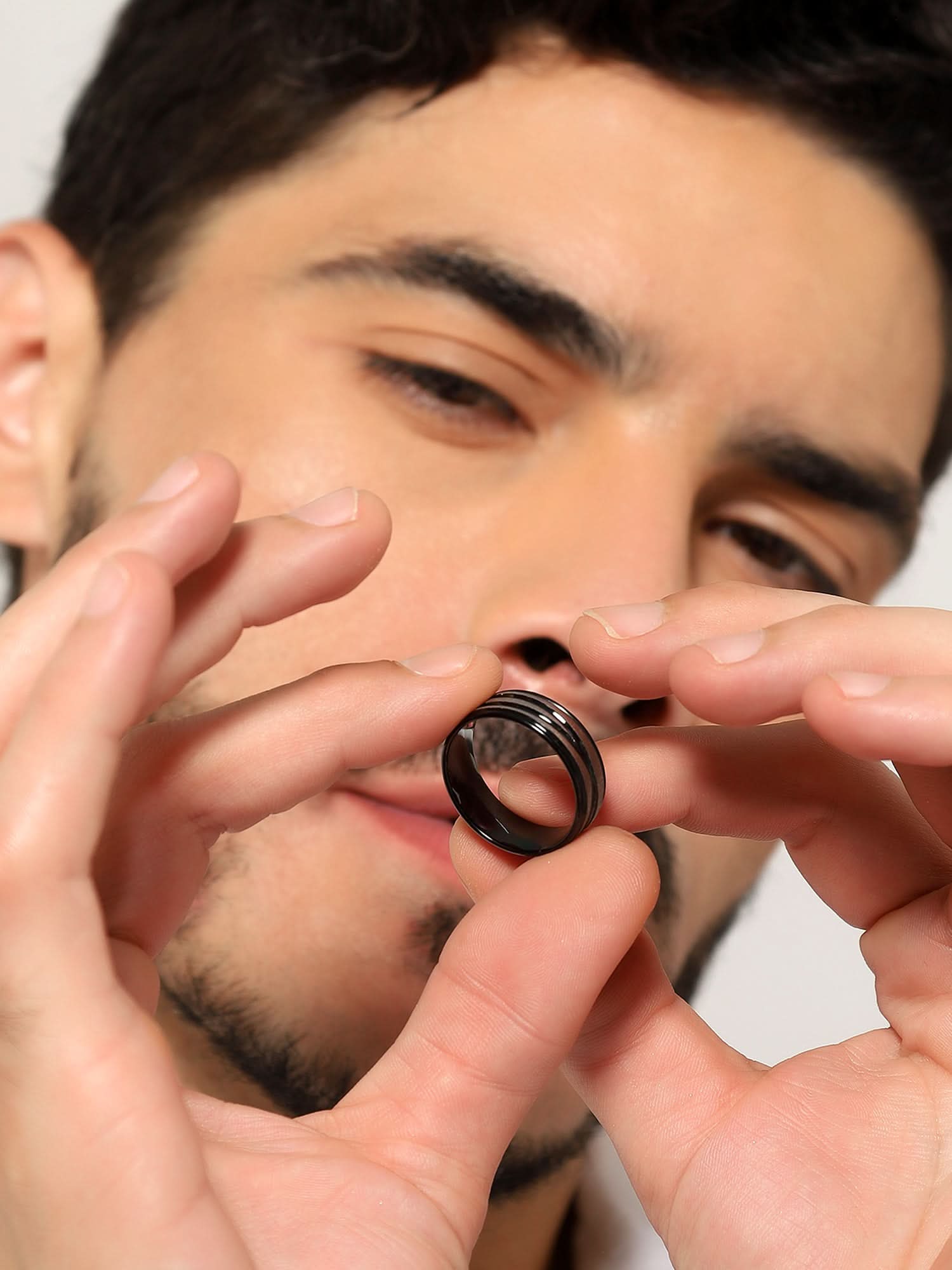 Model wearing Crossover Line Ring in black — men's black ring styled on hand