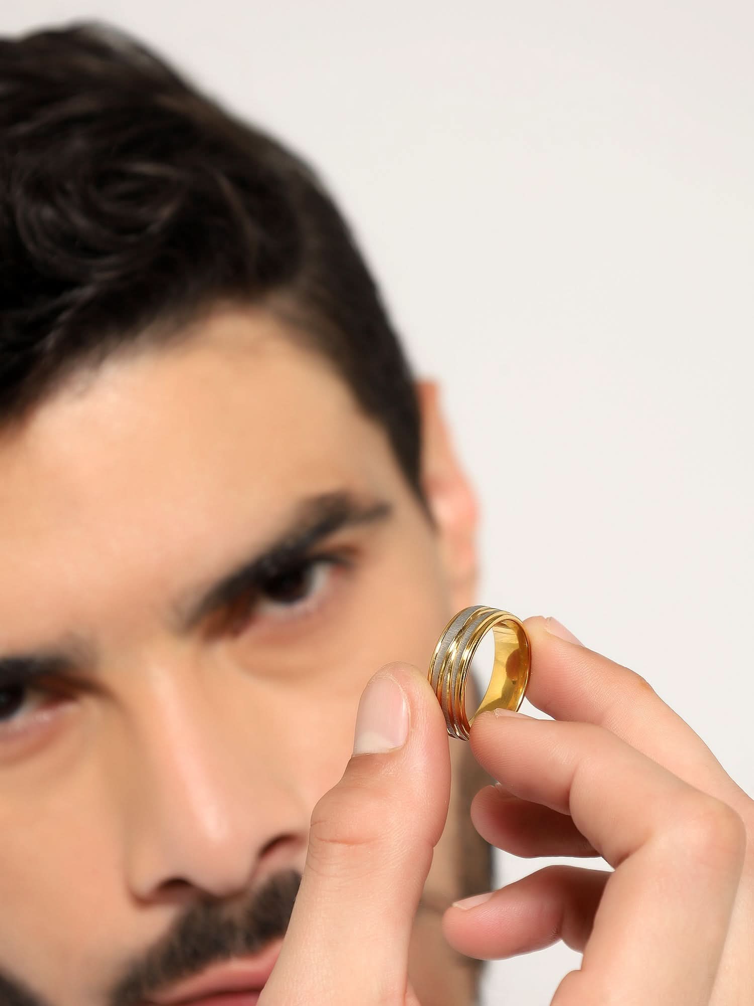 Model wearing Crossover Line Ring in gold — men's gold ring styled on hand