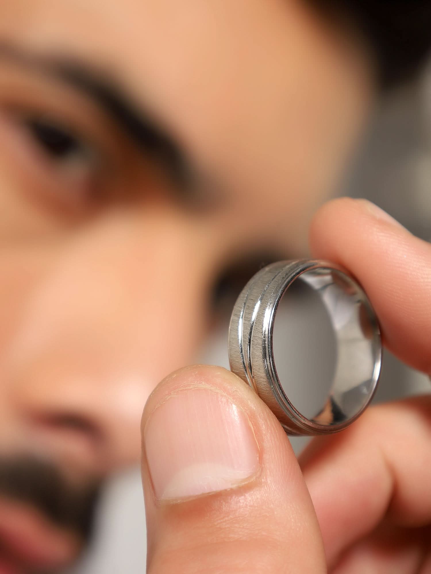 Model wearing Crossover Line Ring in silver — men's silver ring styled on hand
