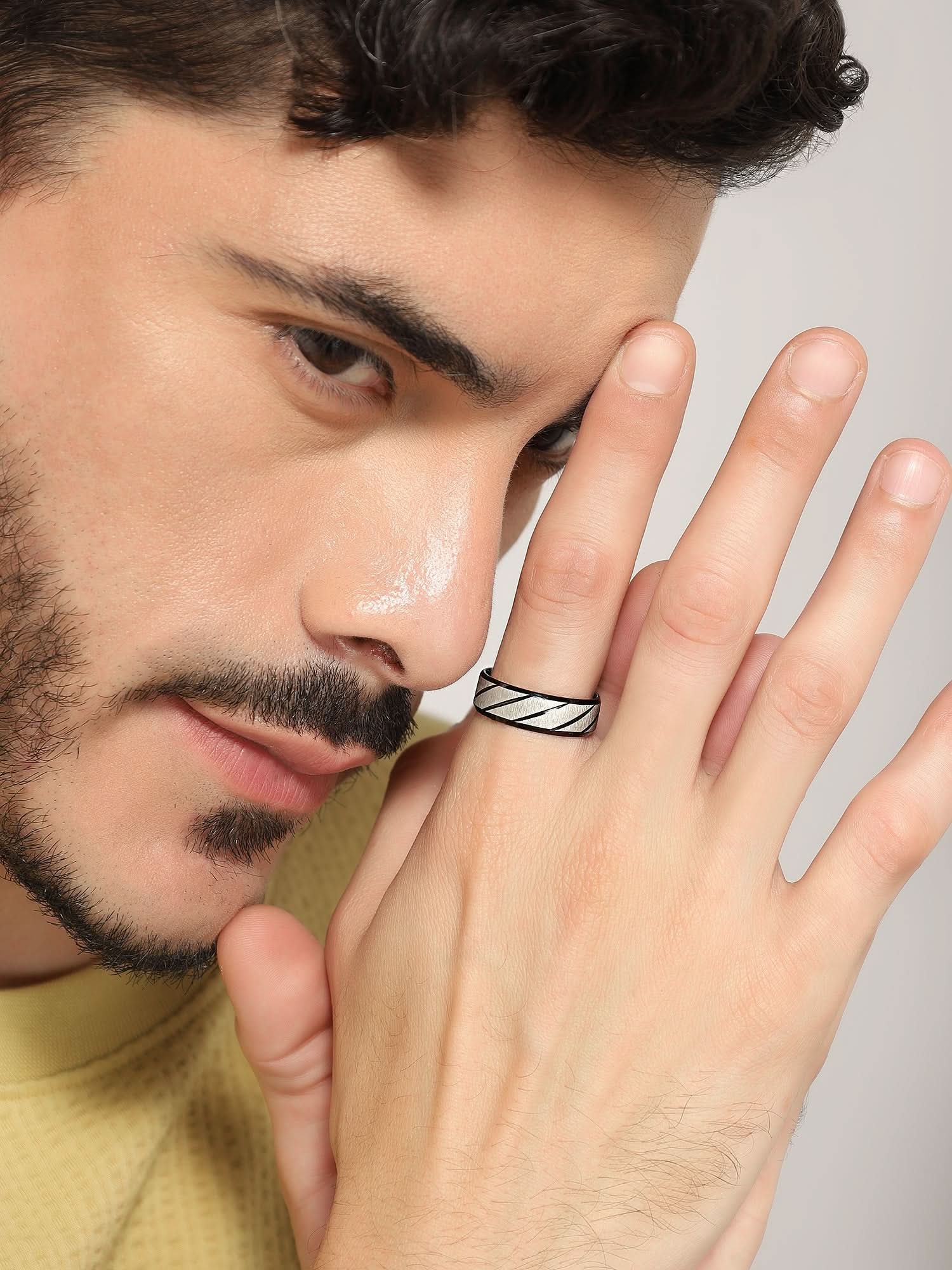 Model wearing Frosted Wave Carved Knuckle Ring in black — men's black ring styled on hand