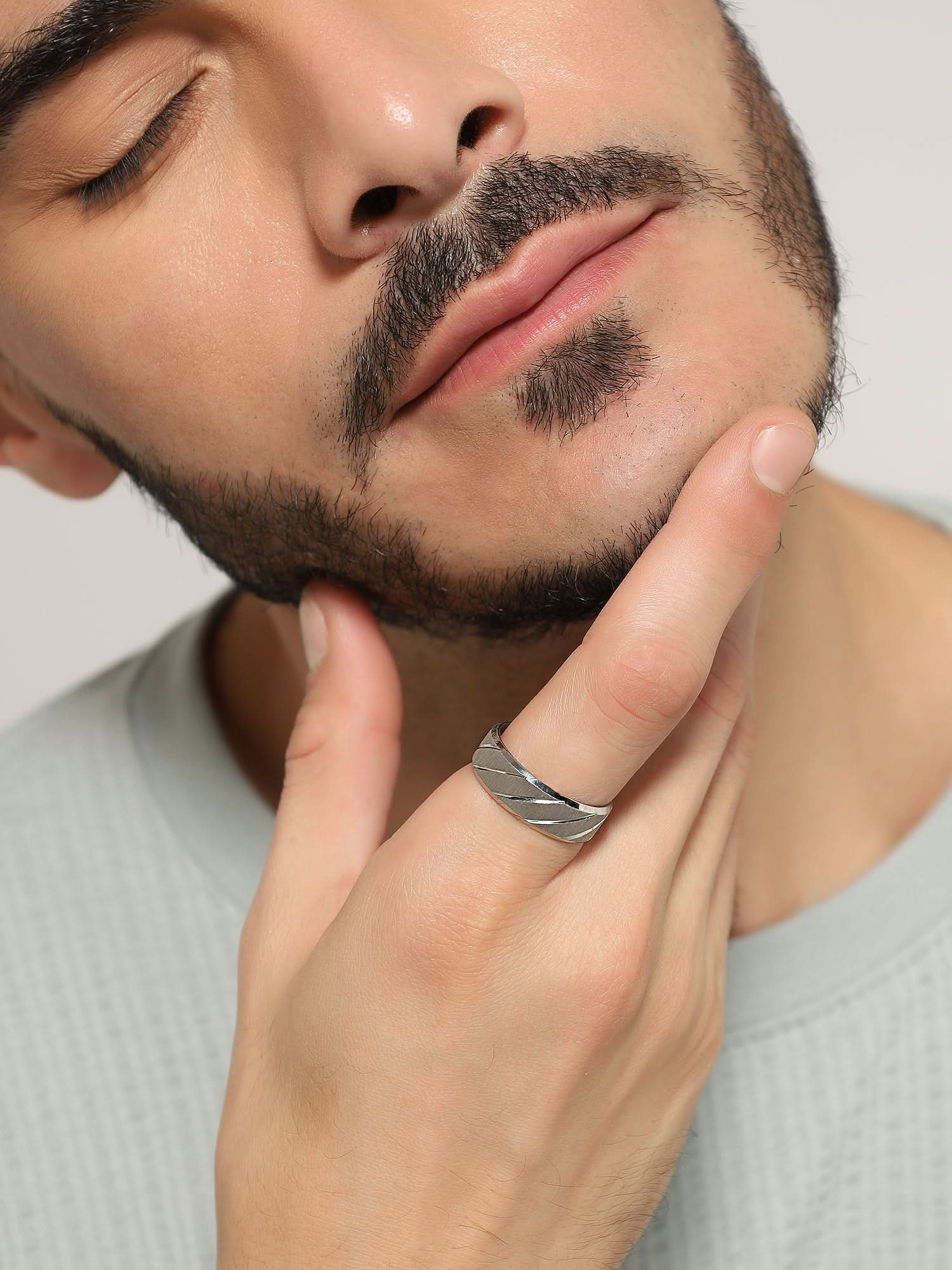 Model wearing Frosted Wave Carved Knuckle Ring in silver — men's silver ring styled on hand