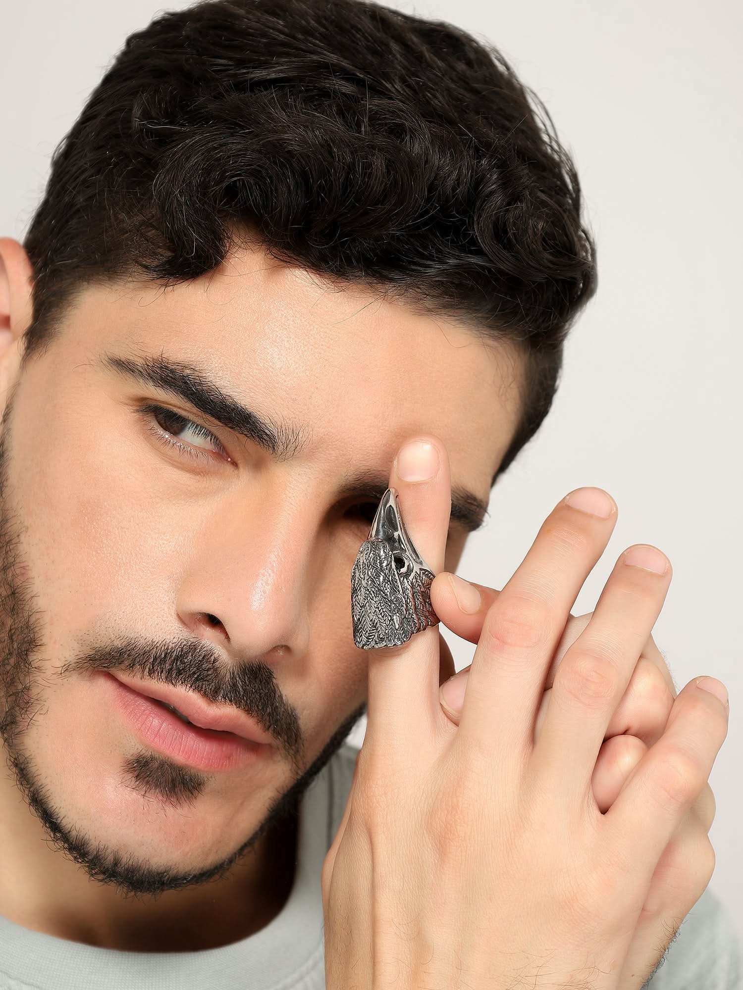 Model wearing Retro Punk Eagle Ring in silver — men's silver ring styled on hand