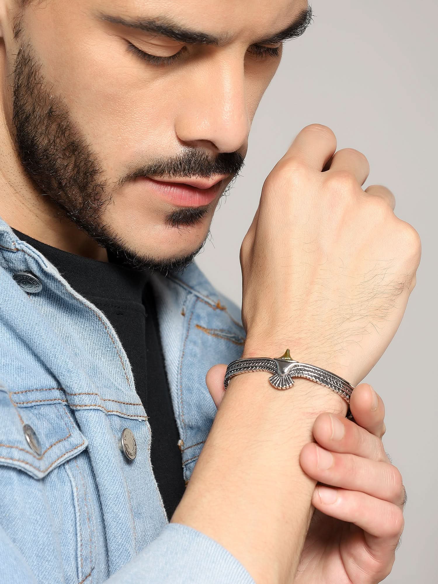 Side view of silver eagle cuff bracelet styled on a man's wrist