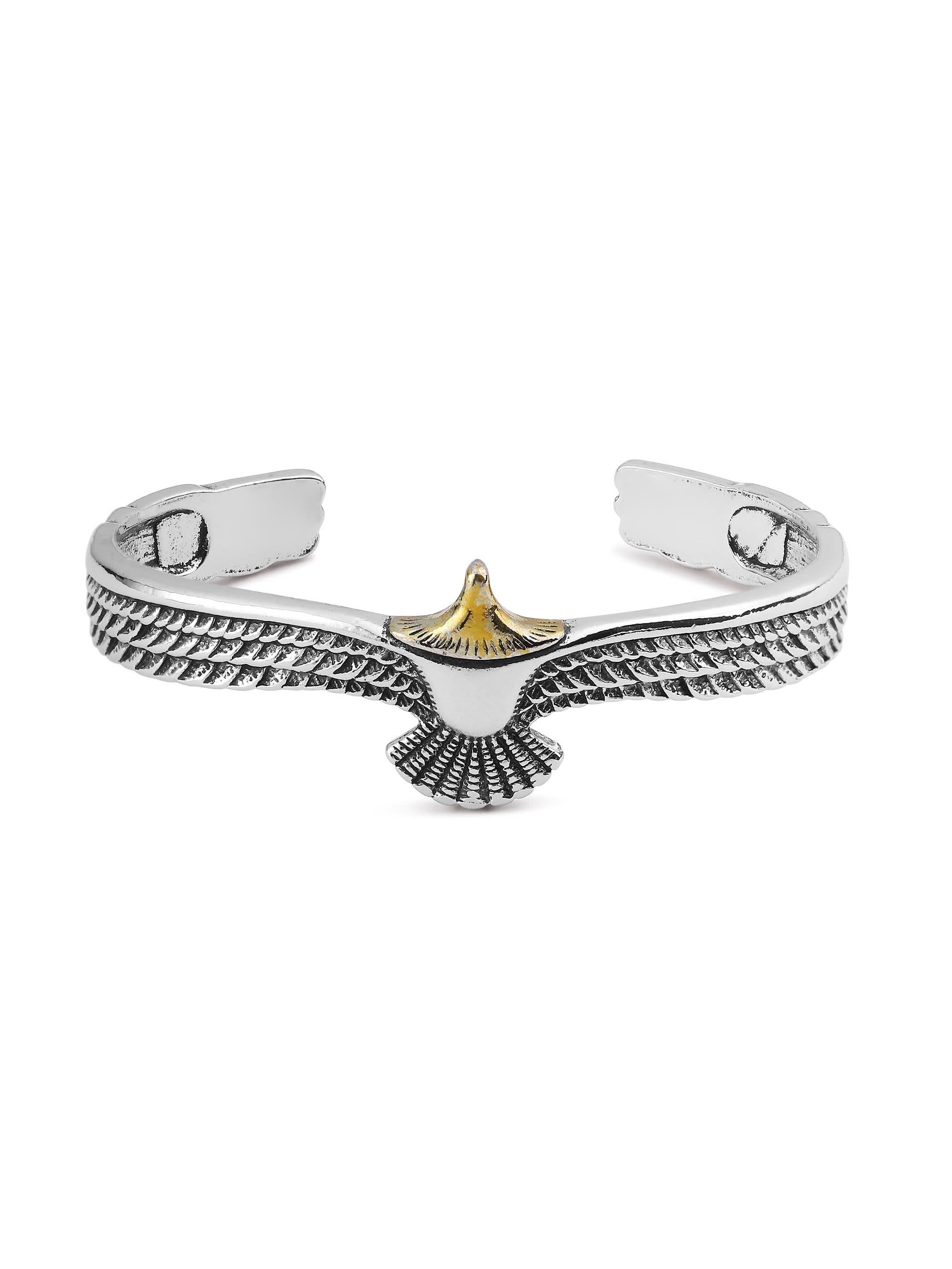 Flat-lay of silver eagle cuff bracelet showing spread-wing centerpiece and gold-tone head