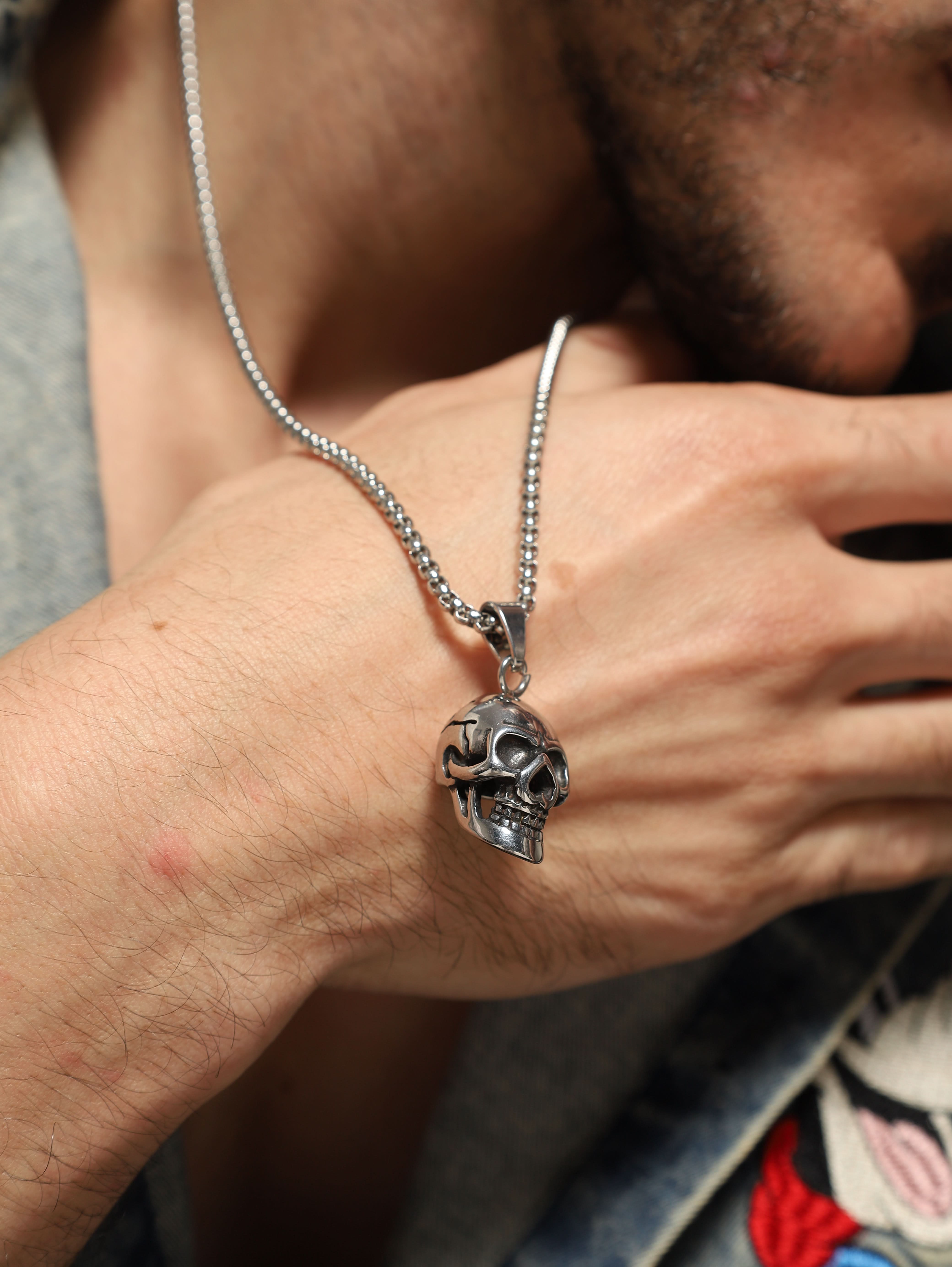 Model wearing Midnight Skull Pendant in silver — men's silver pendant styled on hand