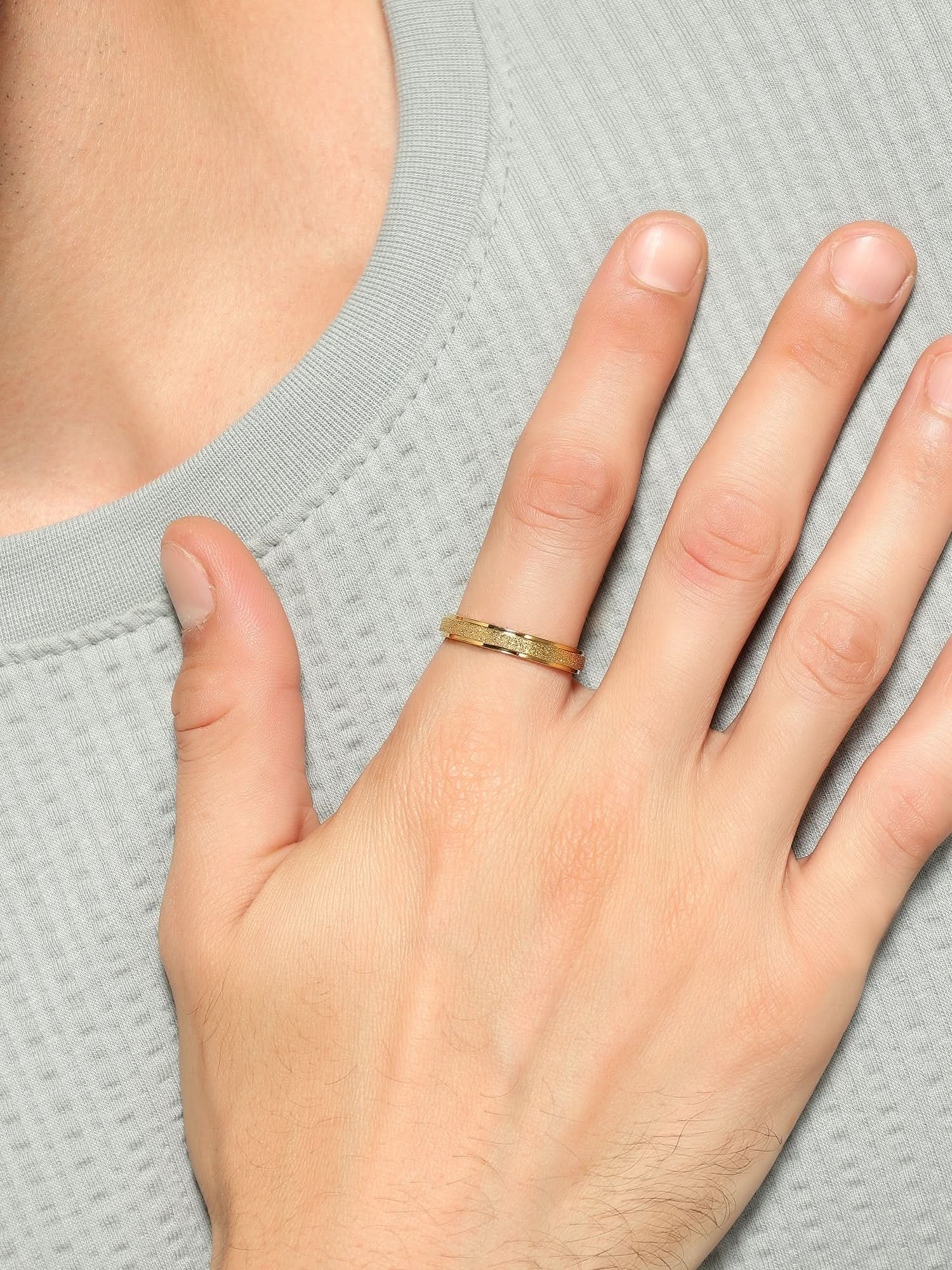 Model wearing Glitty Trose Embossed Ring in gold — men's gold ring styled on hand